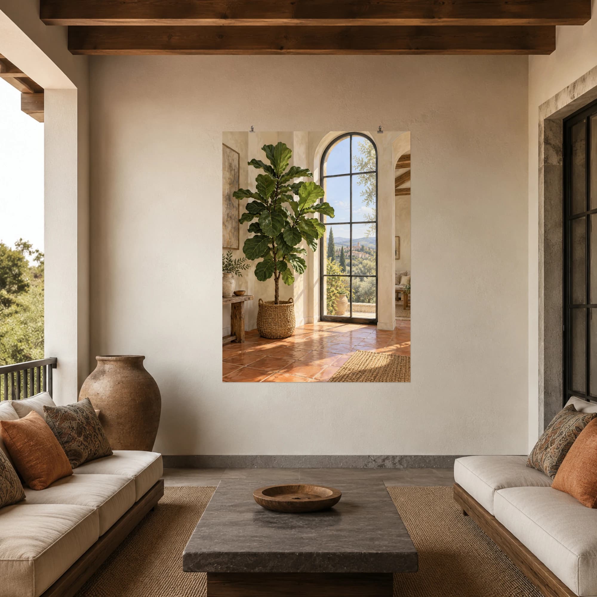 A tall fiddle-leaf fig stands in a woven basket beside an arched window. Terracotta flooring and warm daylight create a relaxed interior scene.