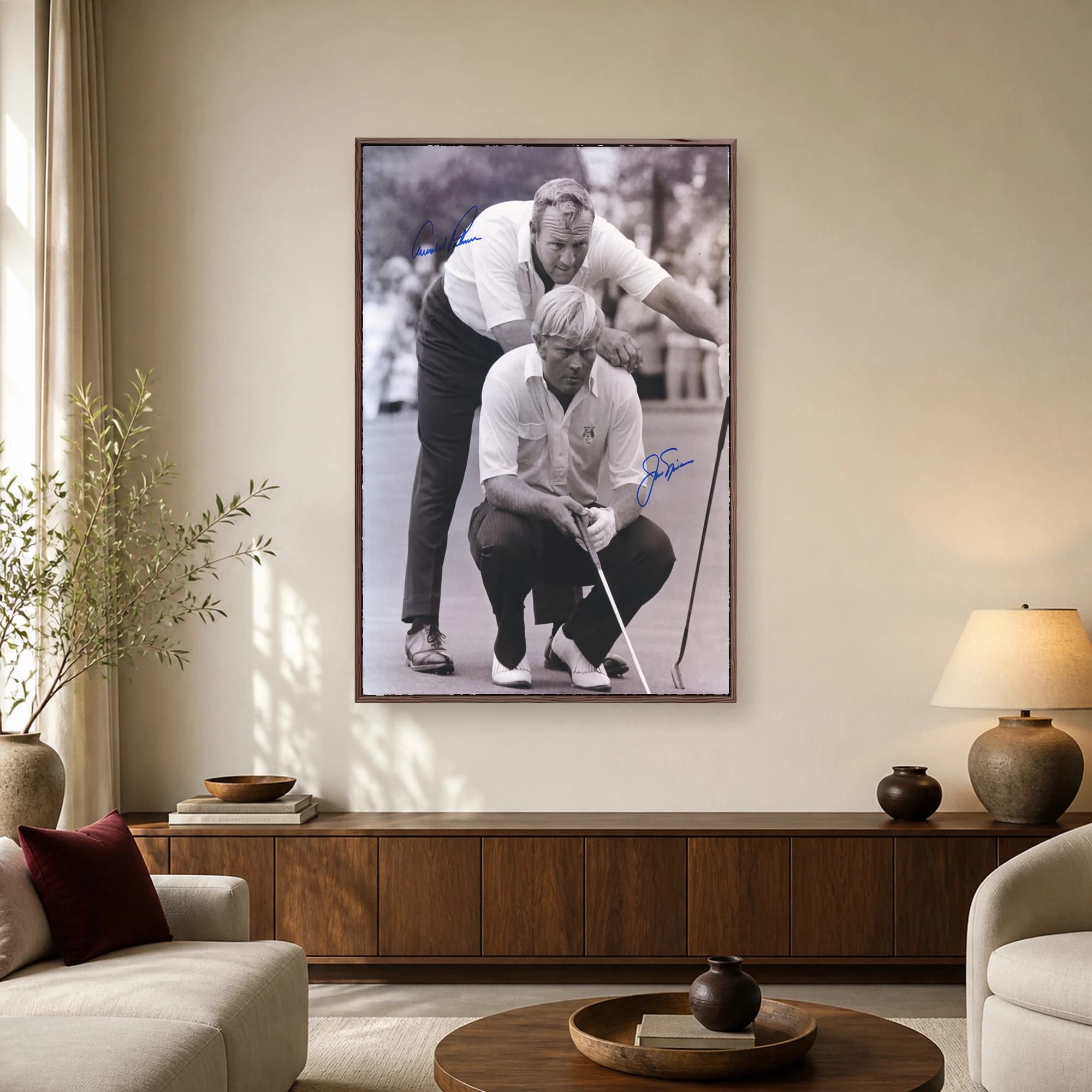 Black and white historic photograph of Arnold Palmer standing behind a seated Jack Nicklaus on a golf course, with signatures.