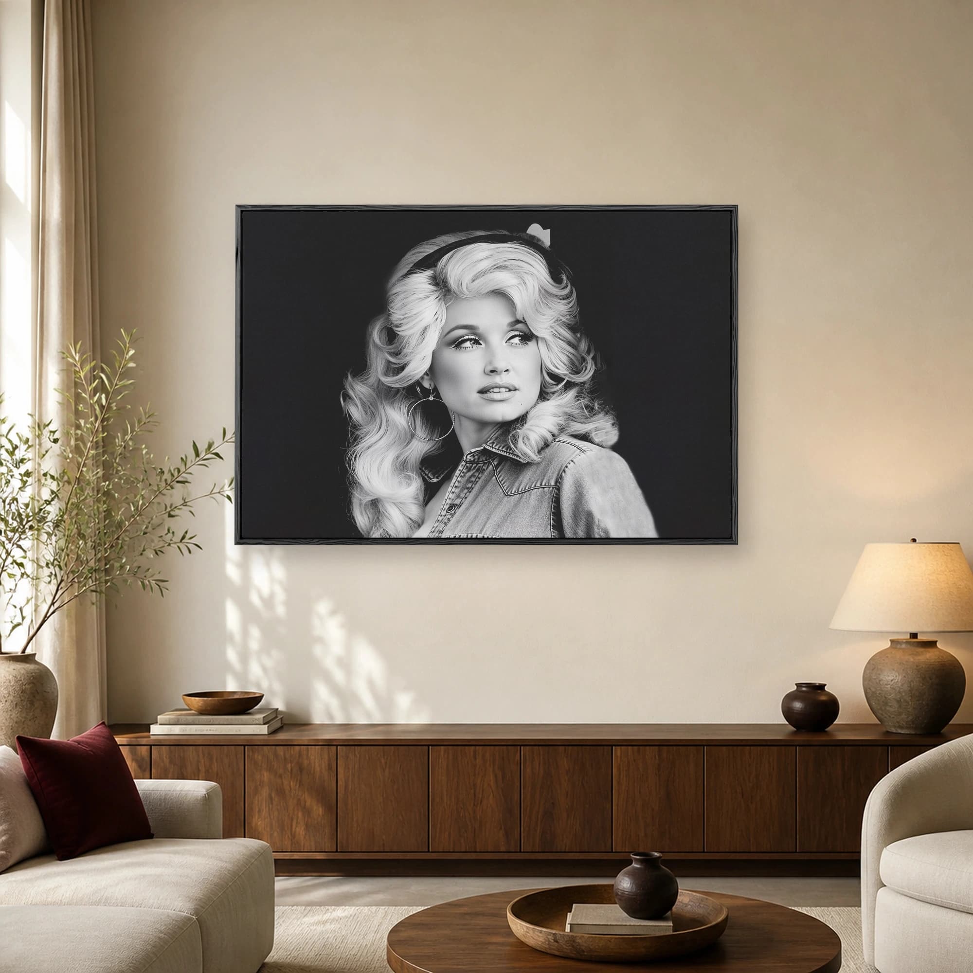Monochrome photographic portrait of country music icon Dolly Parton wearing a denim shirt and voluminous blonde hair against a dark background.