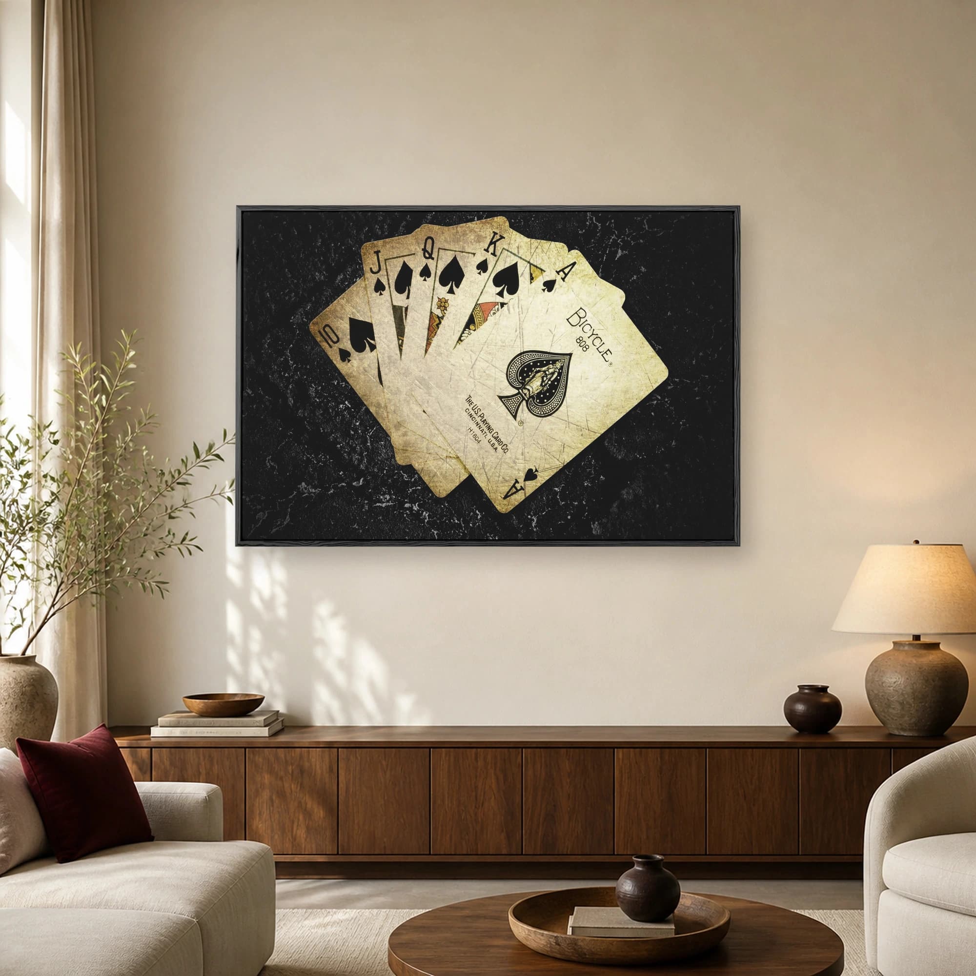 A fanned hand of vintage playing cards showing a royal flush in spades with aged patina against a dark background.