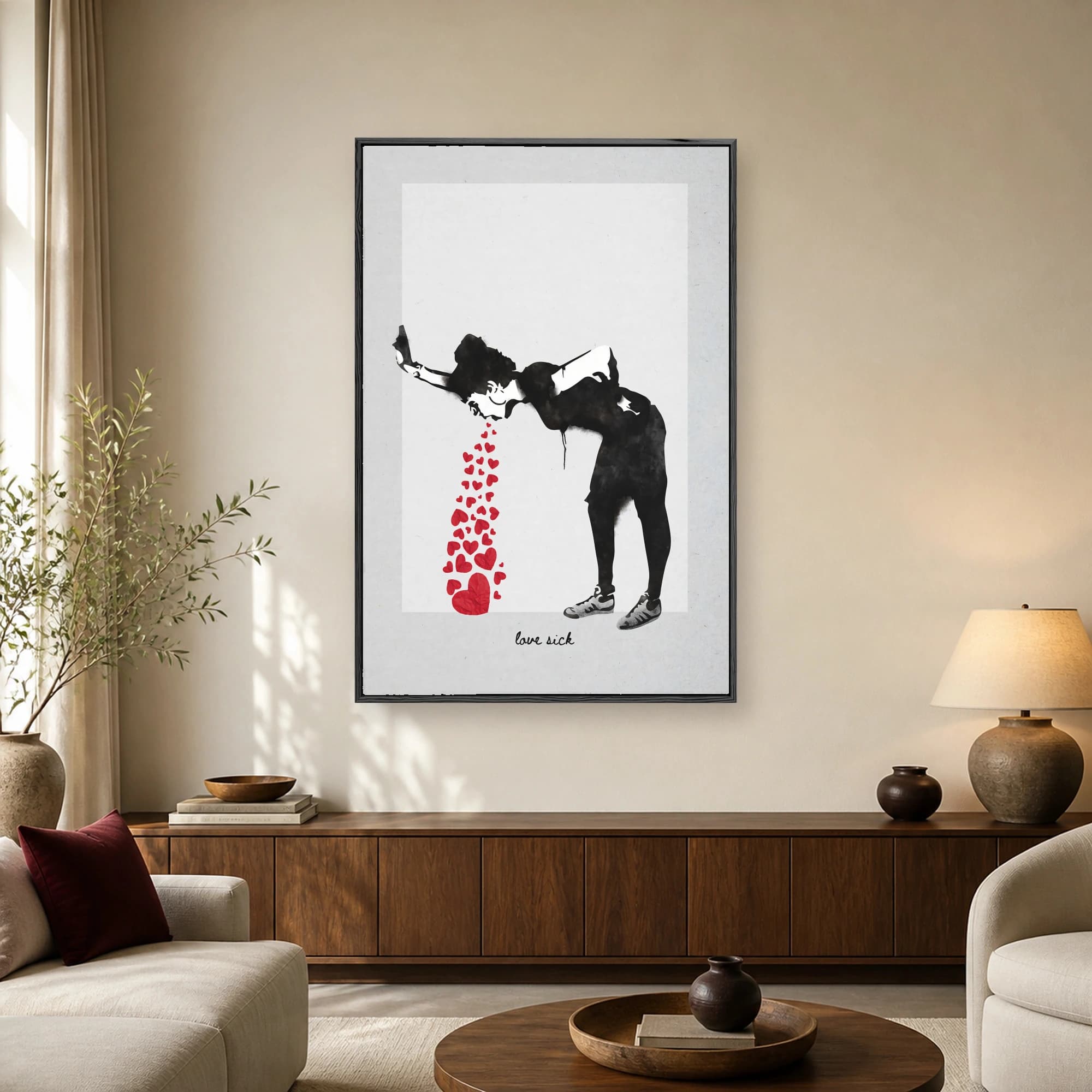 A black silhouette of a figure hunched over and vomiting a stream of red paper hearts against a white background, with love sick text below.