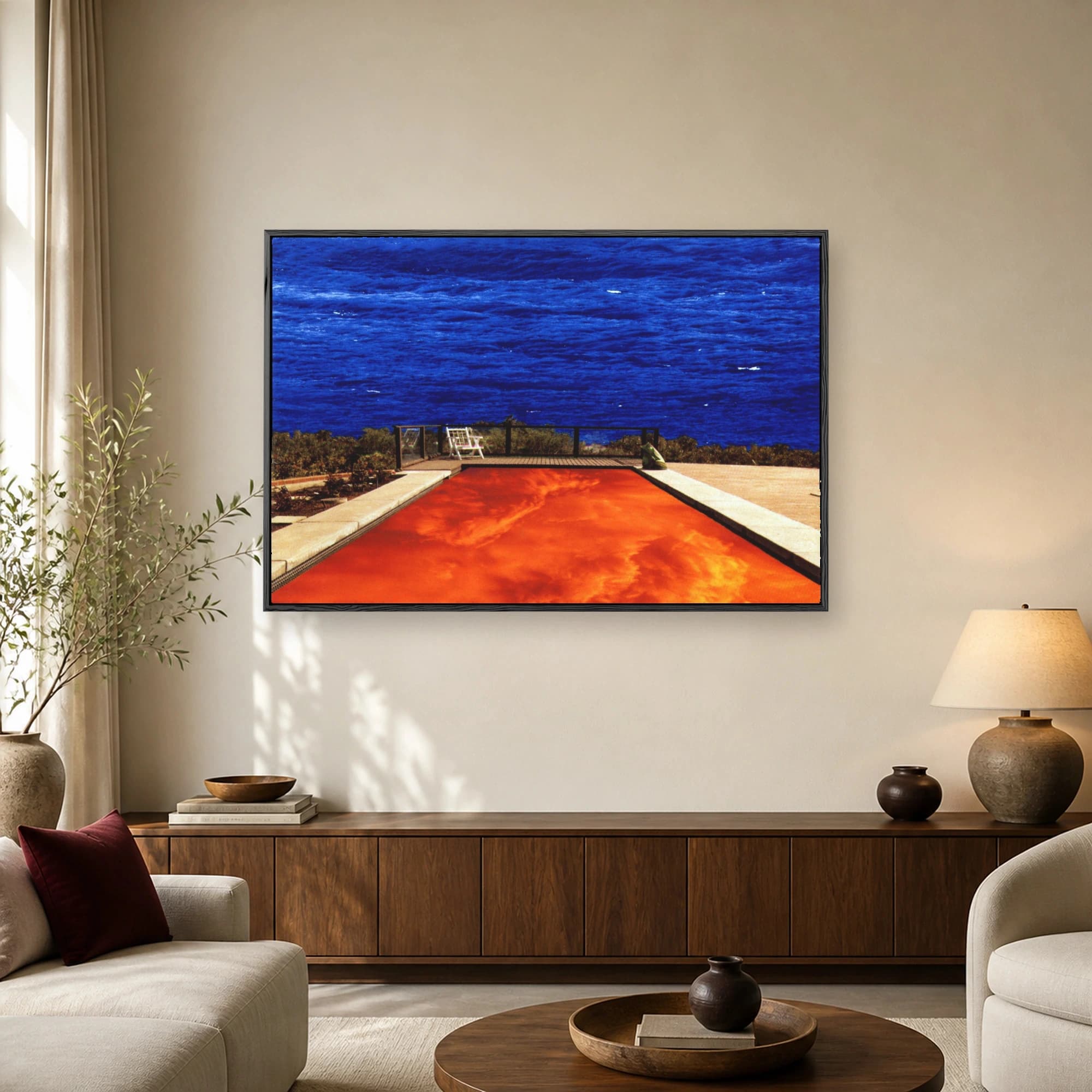 Surreal landscape artwork showing a deep blue ocean above a swimming pool filled with glowing orange fiery water and a solitary white chair on a deck.