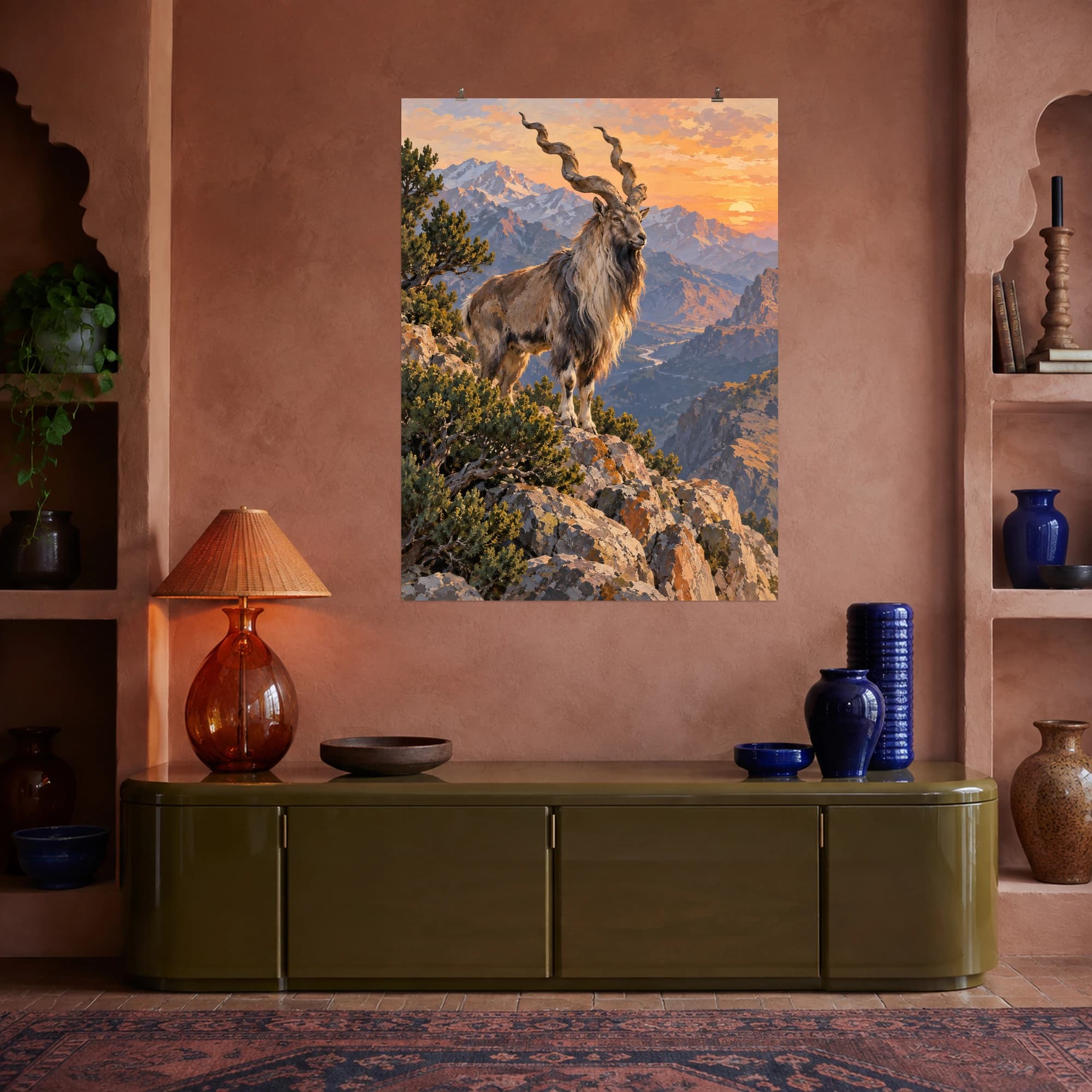 This gouache-style composition features a markhor with long spiral horns standing on a rocky mountain ridge with juniper shrubs and soft apricot evening light. Expressive brushwork and a balanced palette bring warmth and character to your space.