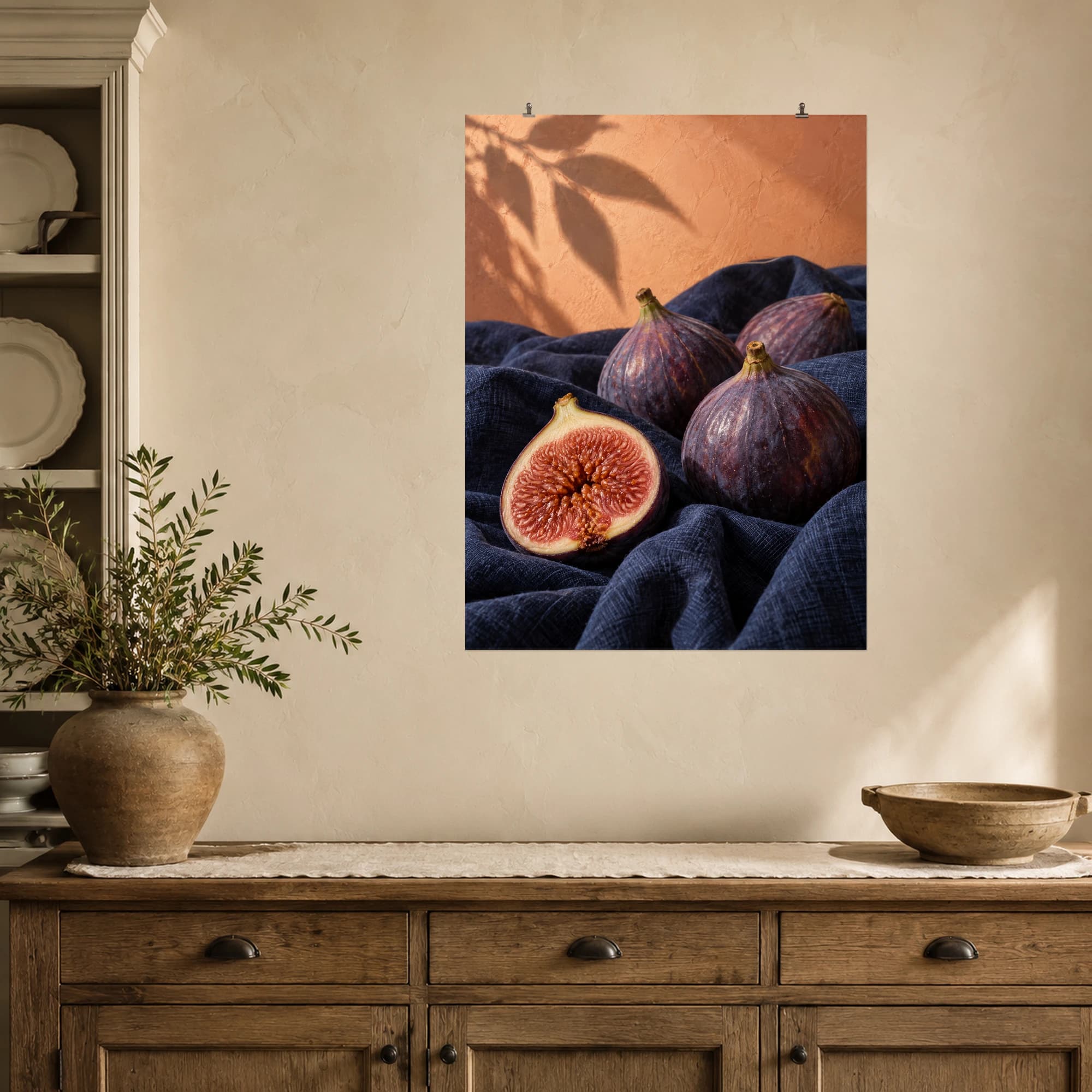 Ripe figs and a cut fruit rest on indigo linen beneath soft afternoon light.