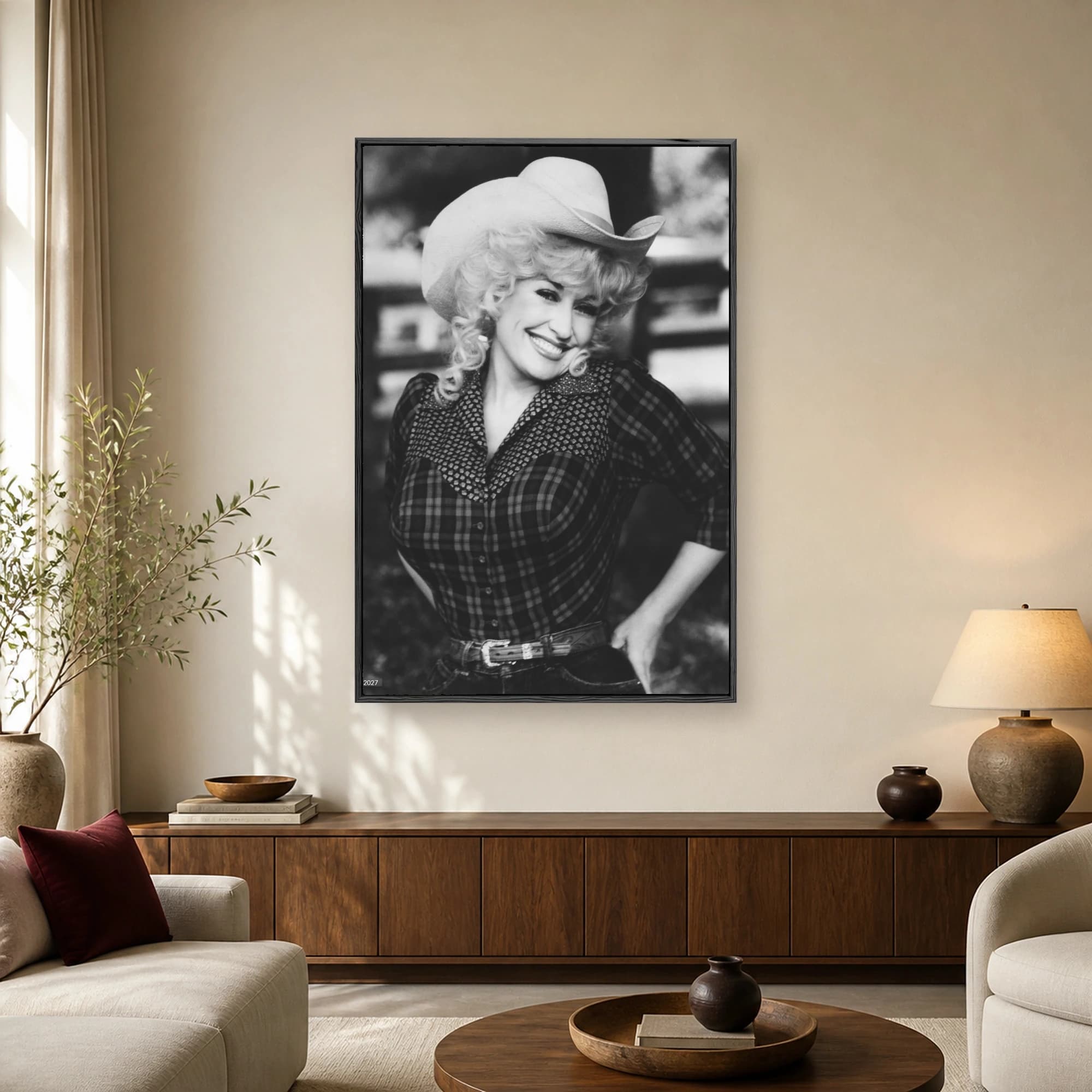 Black and white portrait of Dolly Parton wearing a cowboy hat and plaid shirt while smiling warmly.