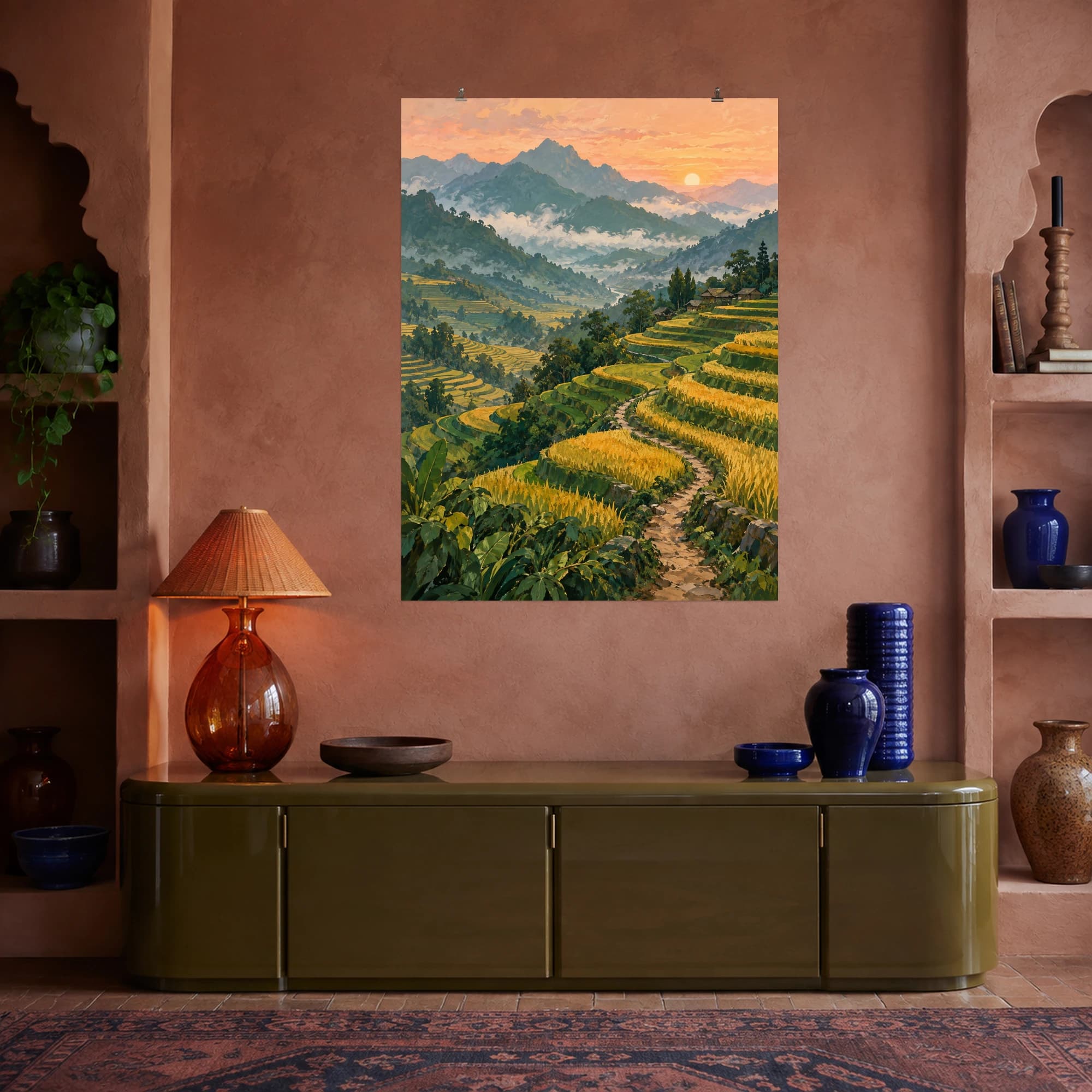 This gouache-style composition features sweeping amber and emerald rice terraces following rolling hills, a narrow winding footpath, distant misty mountains and a muted peach sky. Expressive brushwork and a balanced palette bring warmth and character to your space.