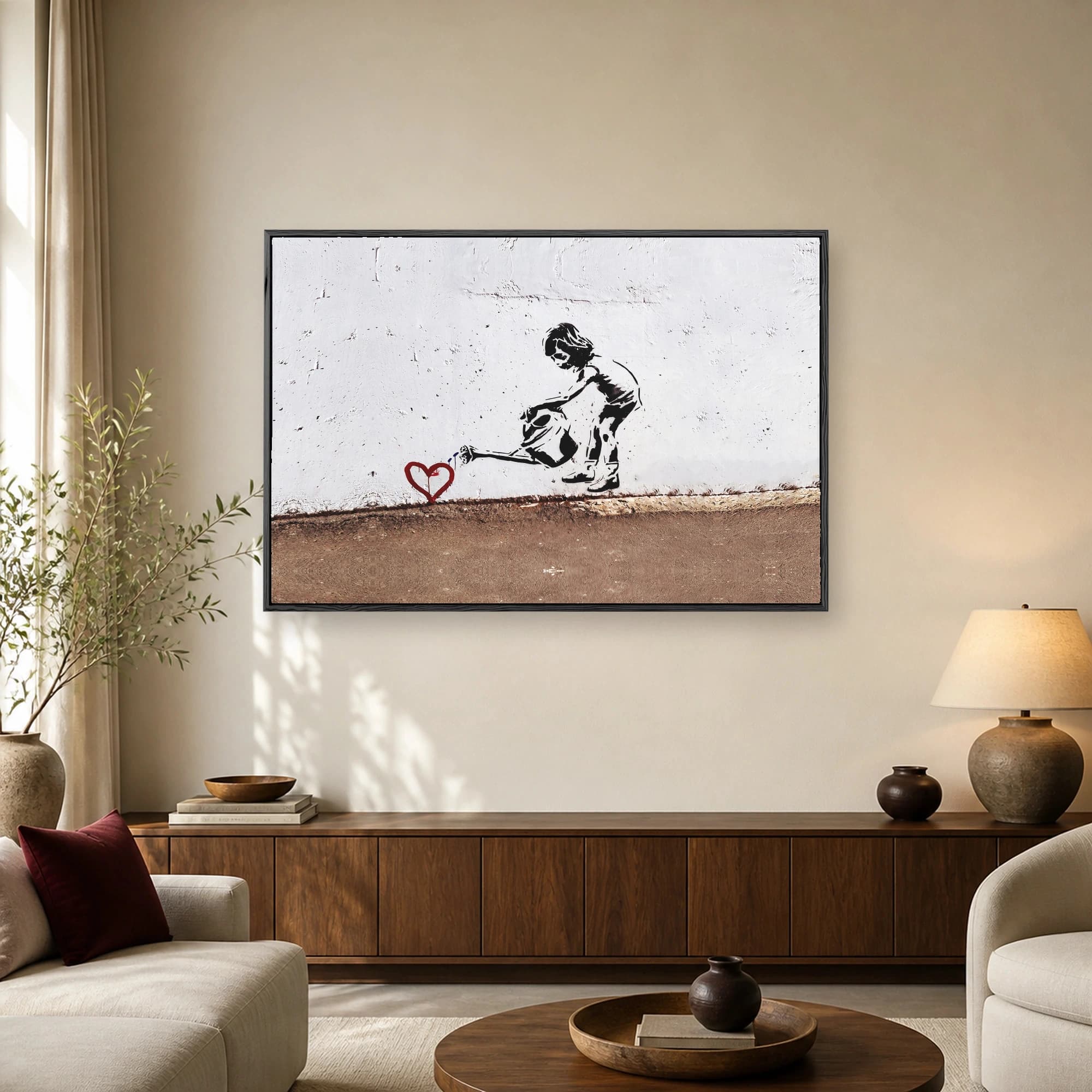 Stenciled black and white silhouette of a young girl watering a red heart on a textured white wall
