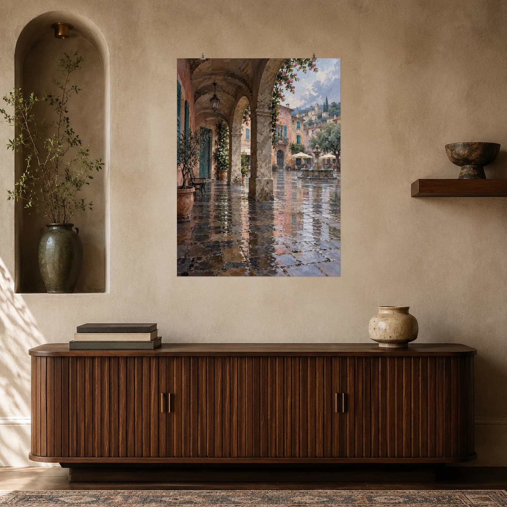 This gouache-style composition features a quiet covered stone arcade beside a rainwashed village square, muted rose plaster and turquoise shutters reflected on wet cobblestones. Expressive brushwork and a balanced palette bring warmth and character to your space.