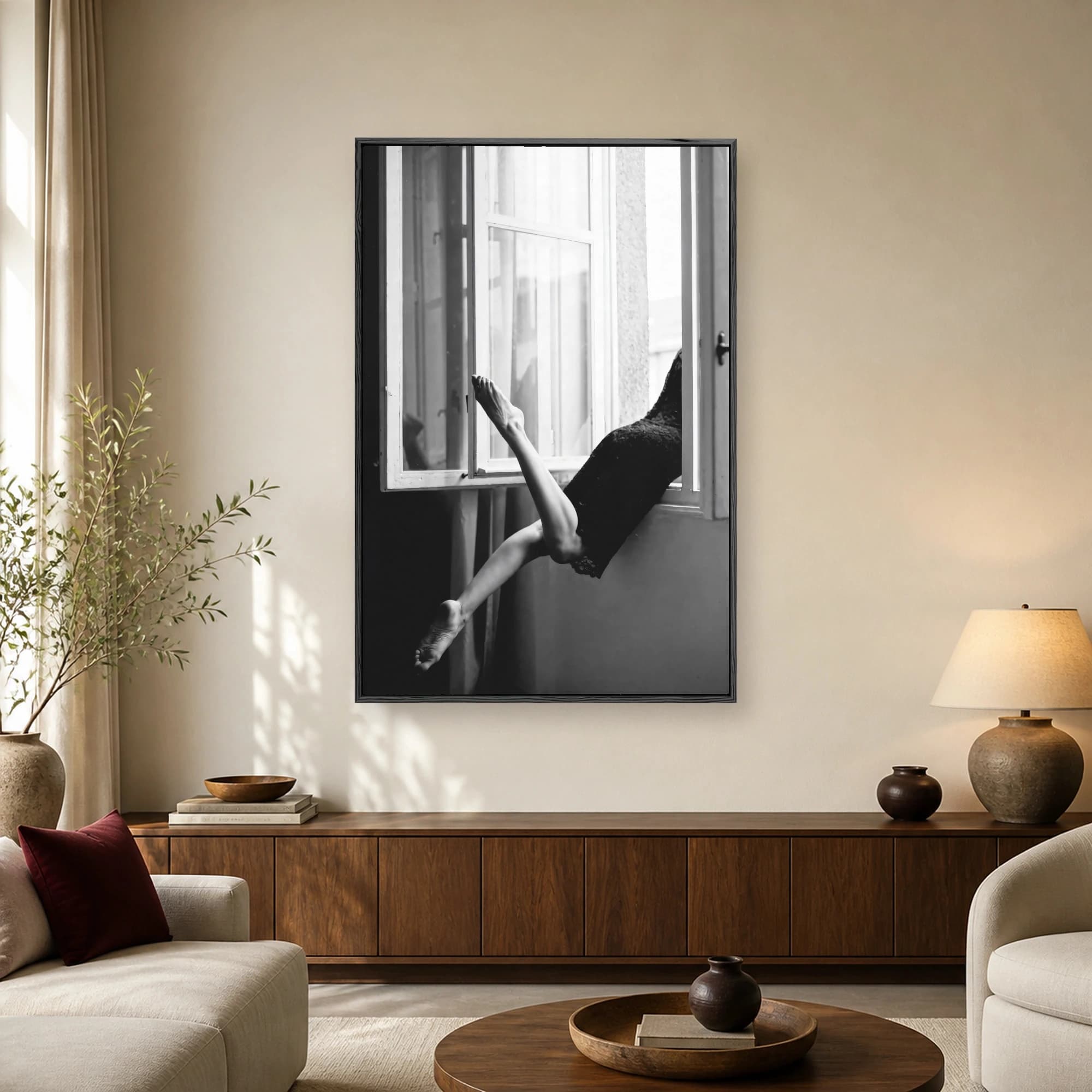 Black and white photograph of a woman in a black dress extending legs out an open window frame