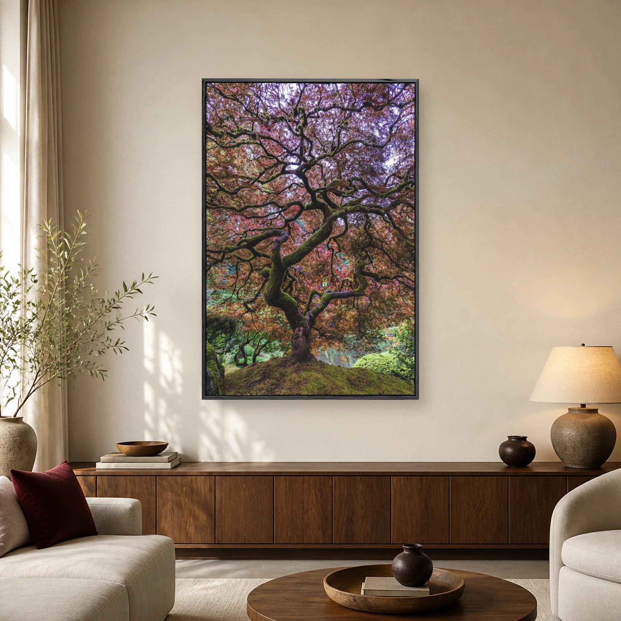 Low-angle fine art photograph of an ancient Japanese maple tree with vibrant red leaves and mossy twisting branches over a green mound