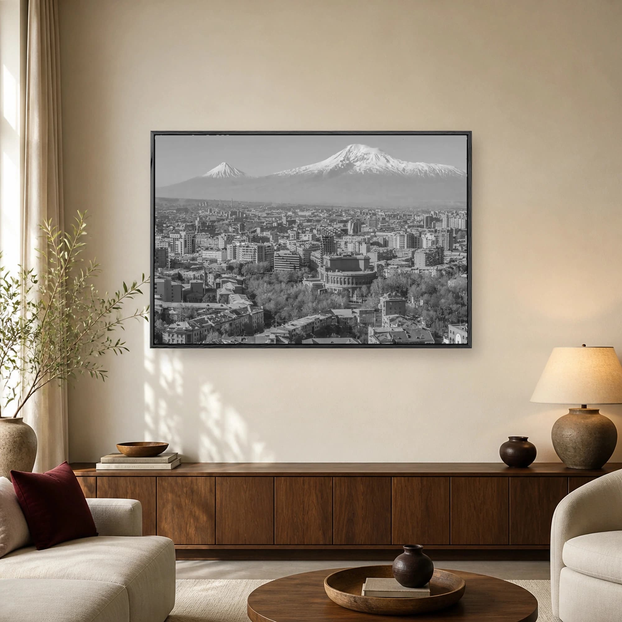 Aerial black-and-white photograph of Yerevan cityscape featuring dense buildings and trees with snow-capped Mount Ararat in the background.