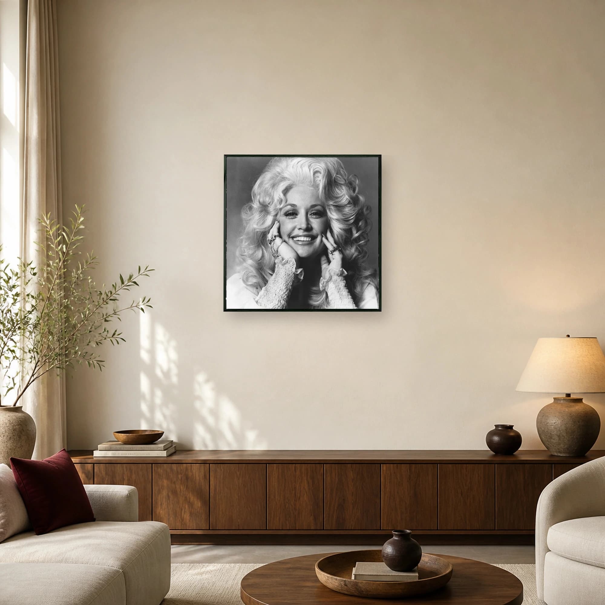 Black and white portrait of Dolly Parton with voluminous blonde hair framing her smiling face, wearing ruffled sleeves and statement rings.