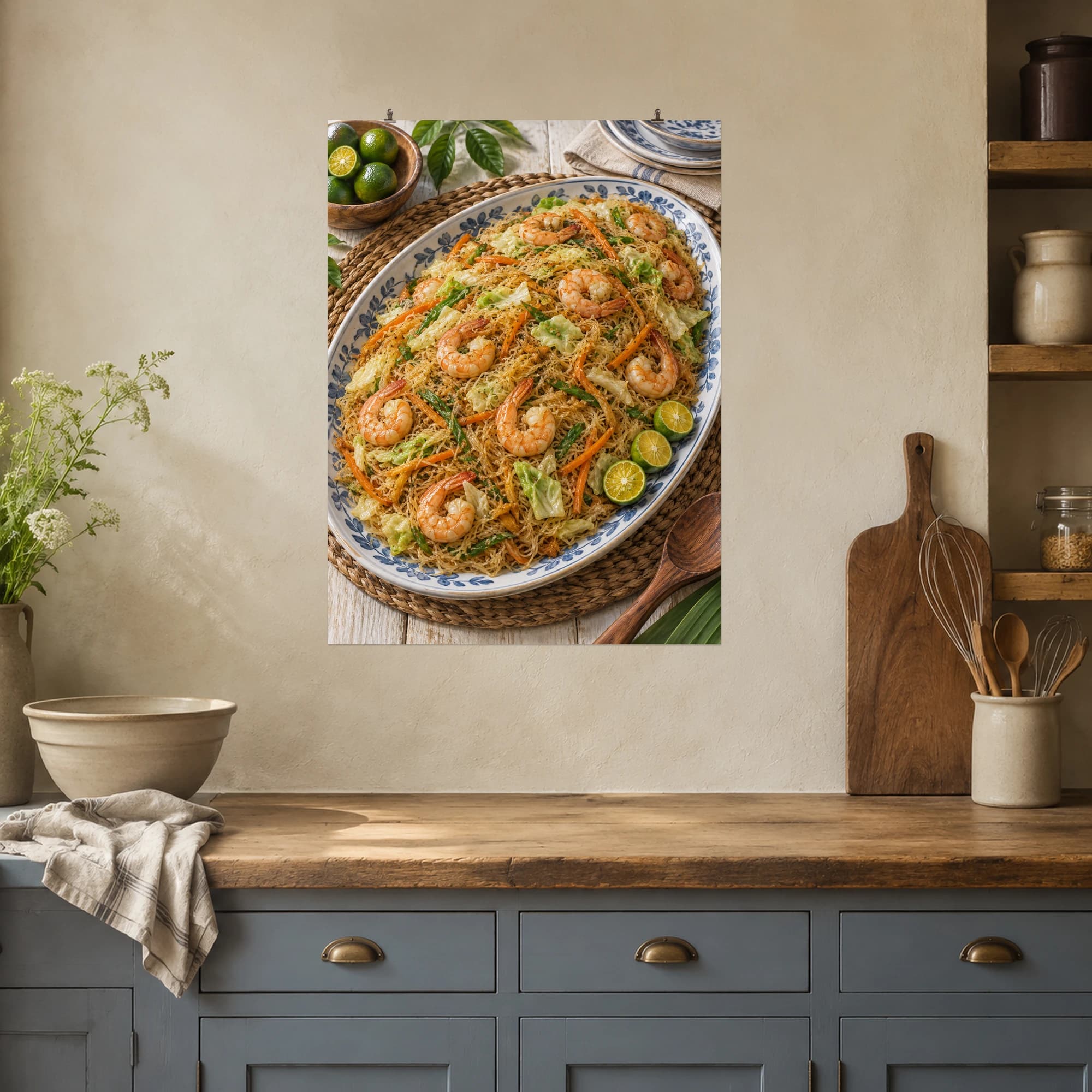 Pancit noodles, vegetables and shrimp fill a generous platter beside fresh calamansi.