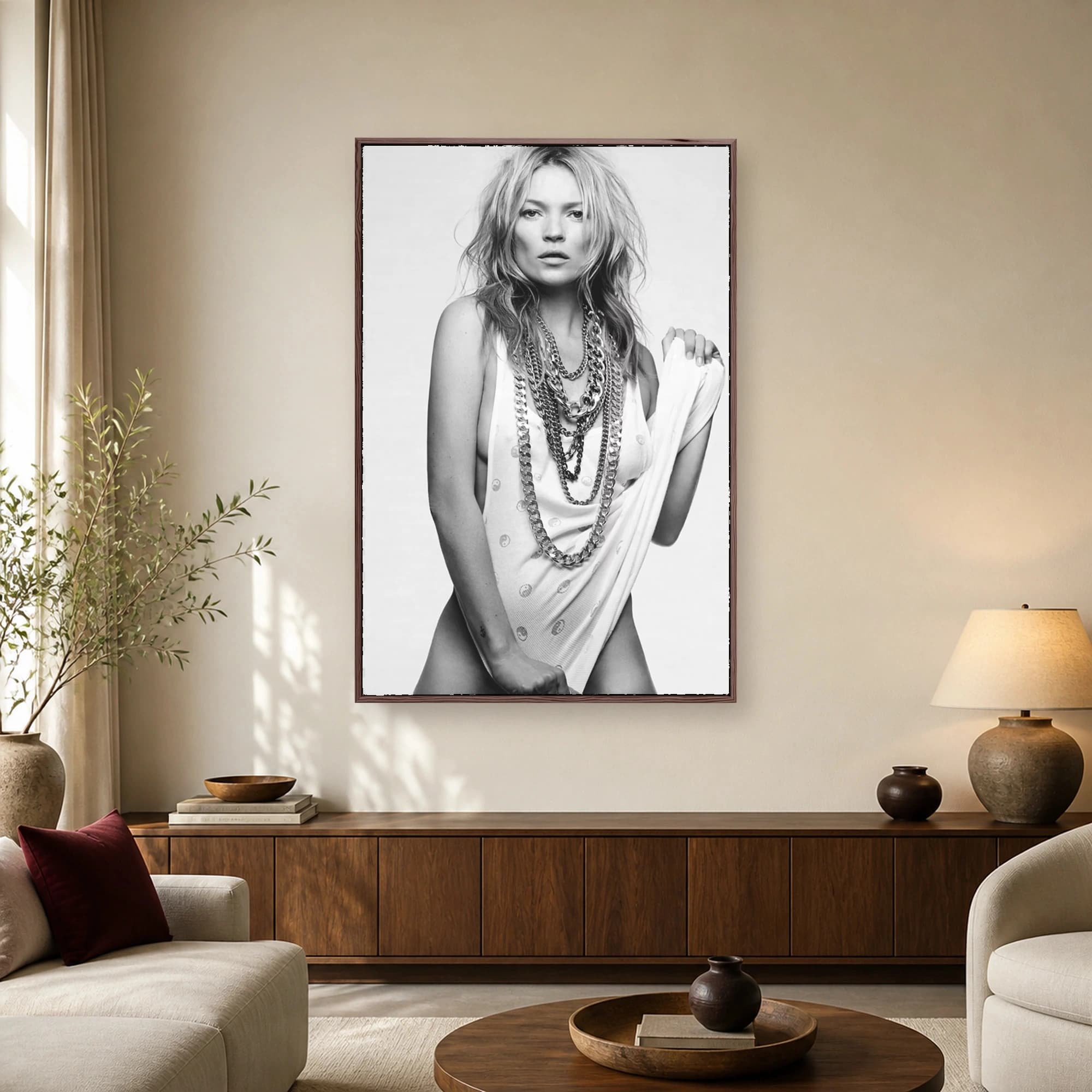 Black and white portrait of supermodel Kate Moss wearing layered heavy chain necklaces and a white tank top with tousled hair and a direct gaze.