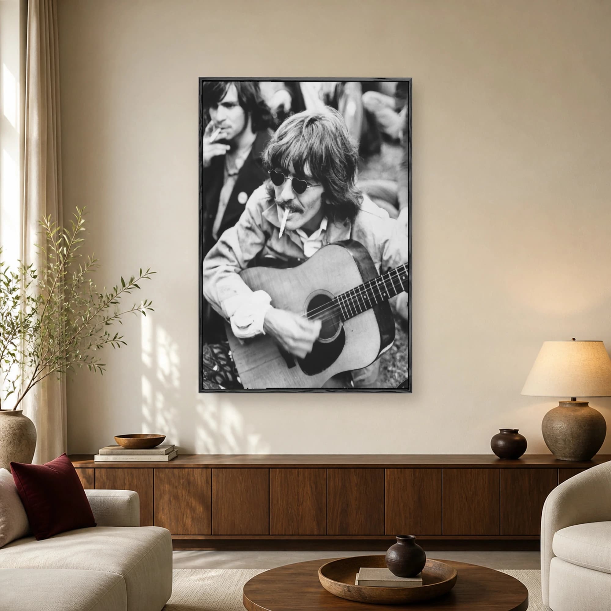 Black and white photograph of George Harrison wearing heart-shaped sunglasses and playing an acoustic guitar while smoking a cigarette.