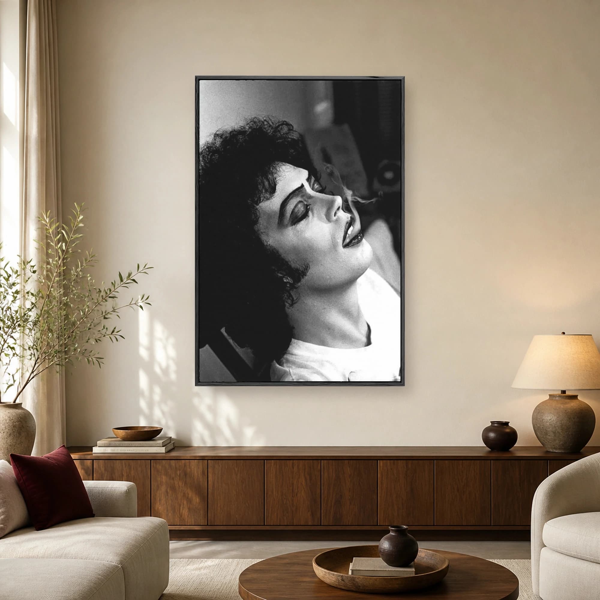 Black and white portrait of Tim Curry as Dr. Frank-N-Furter with dark curly hair, dramatic makeup, and a cigarette, tilting his head back.