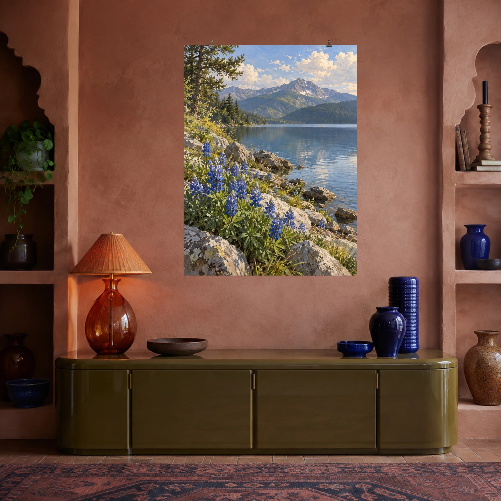 Blue wildflowers grow along a rocky lakeshore beneath distant mountains. Cool water and clear light give the scene an open, restful mood.