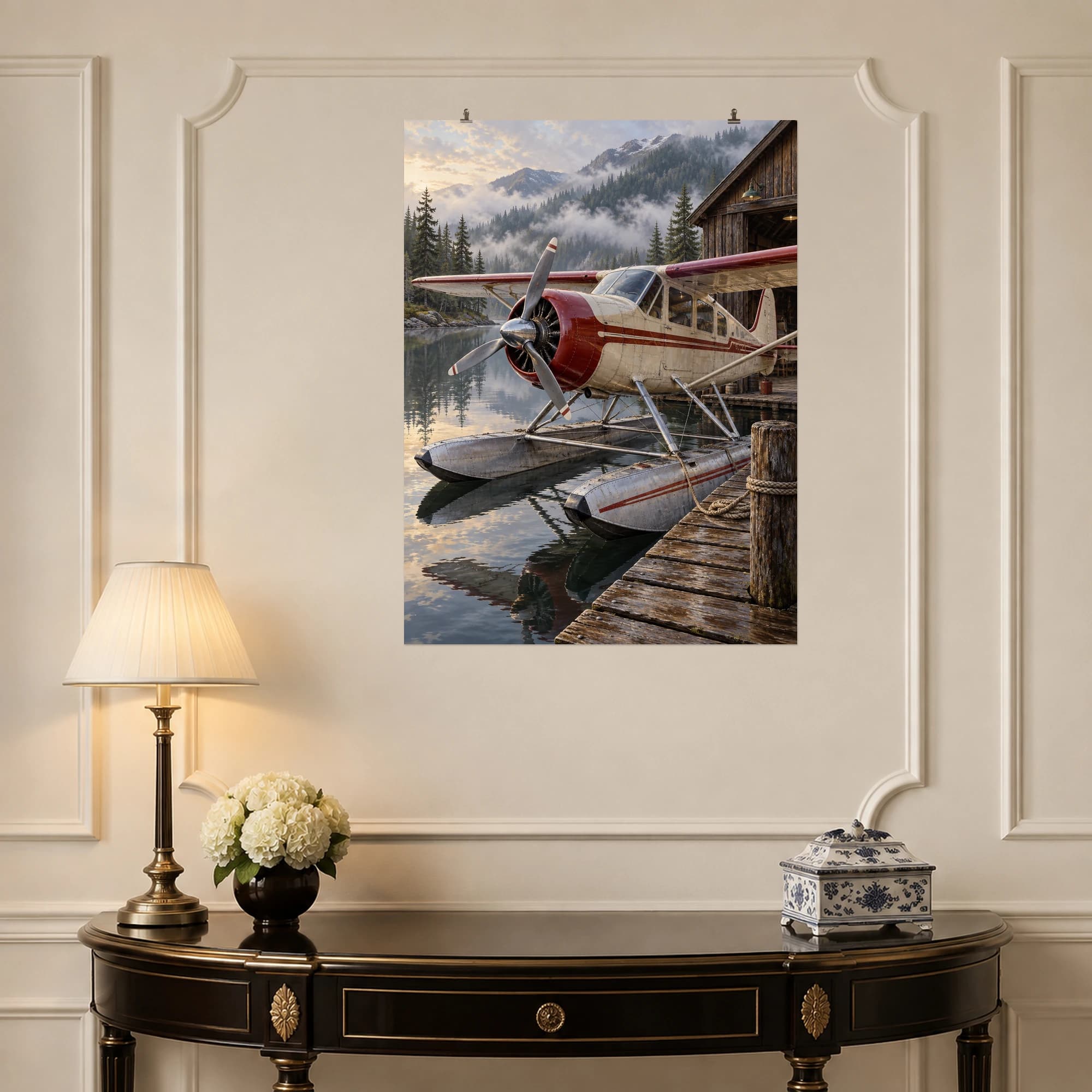 A vintage floatplane rests beside a timber hangar on a misty mountain lake.
