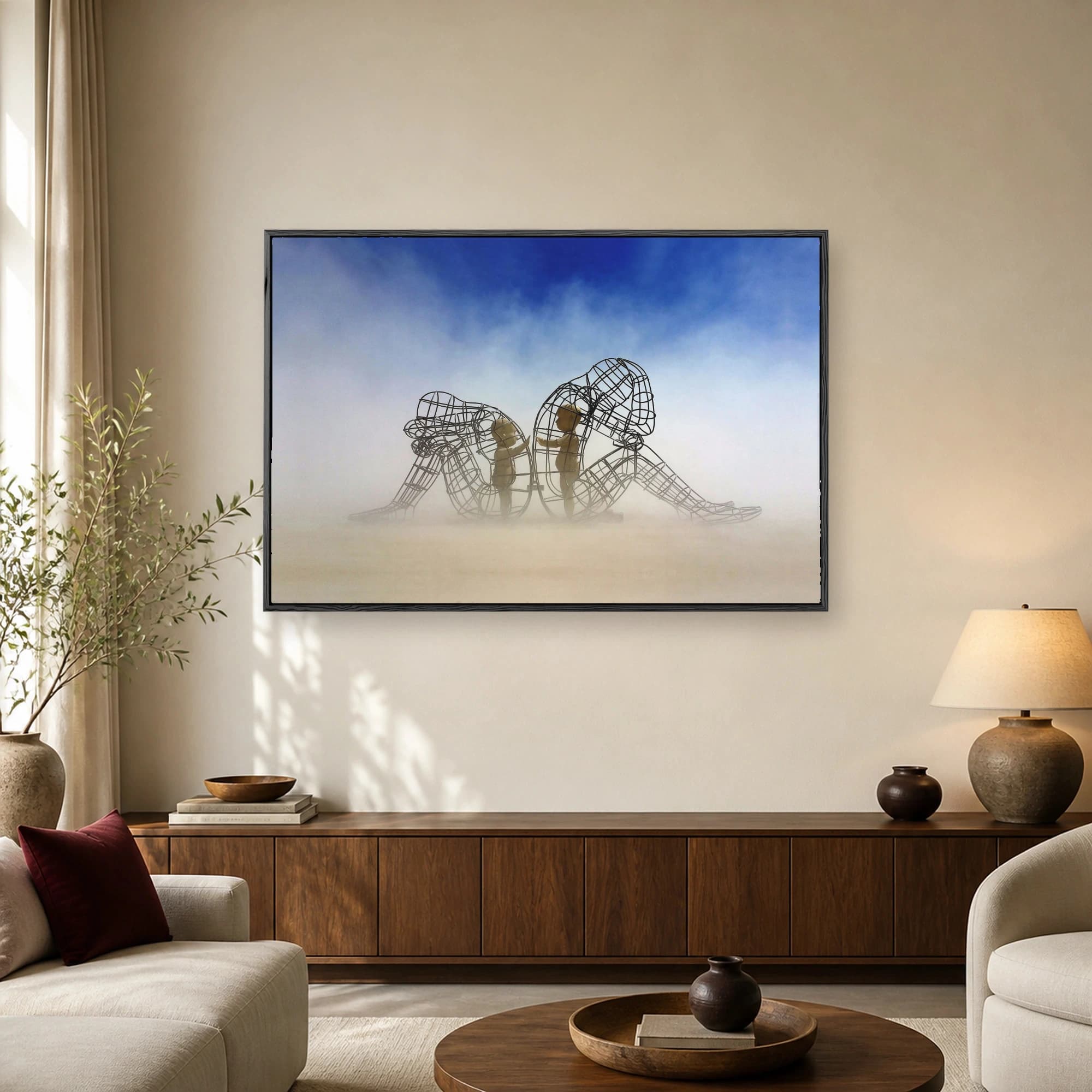 Large metallic wireframe human sculptures in a hazy desert with glowing inner children reaching for each other under a blue sky.