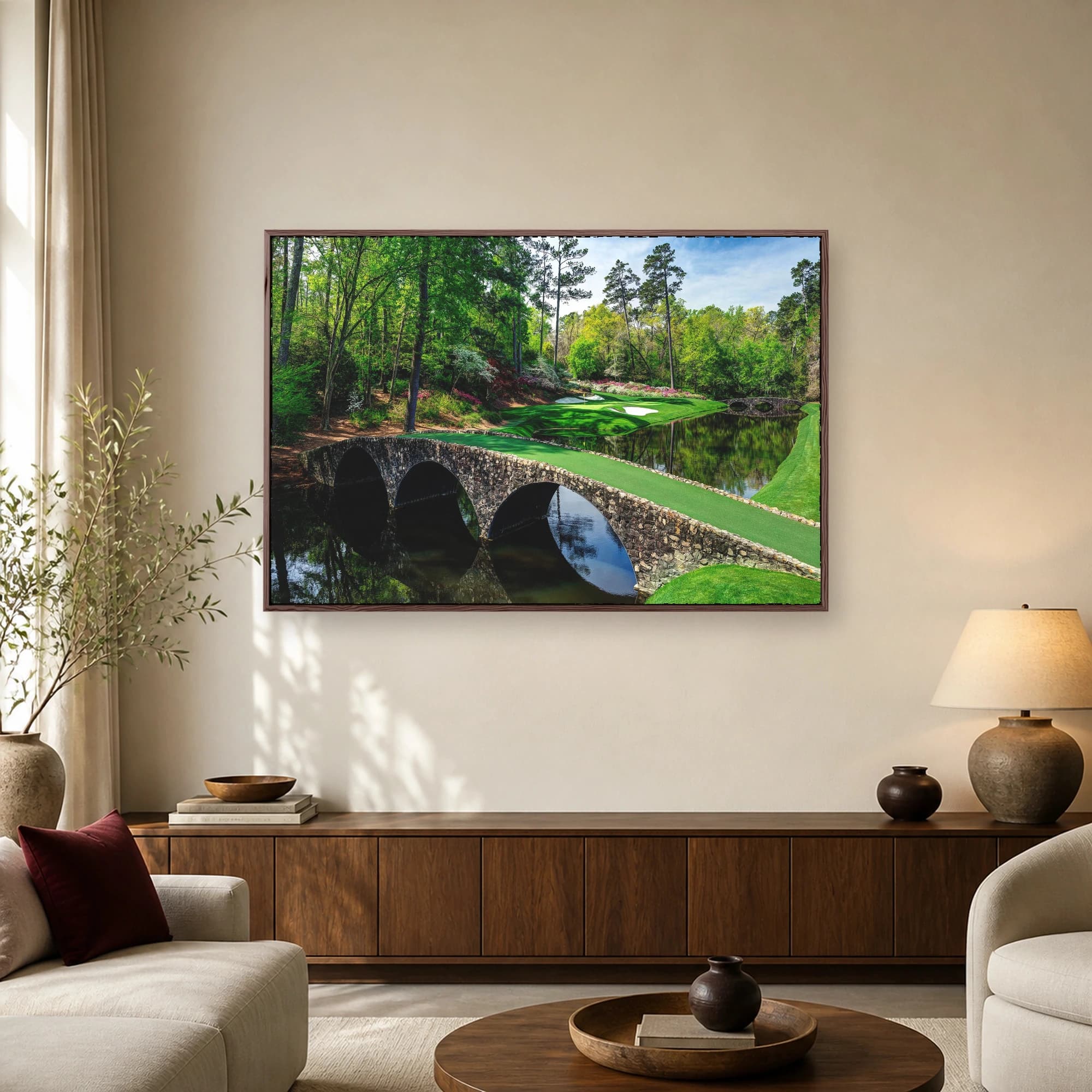 Scenic photograph of the historic stone arch bridge crossing a creek at the Augusta National golf course, surrounded by lush trees and manicured greens.