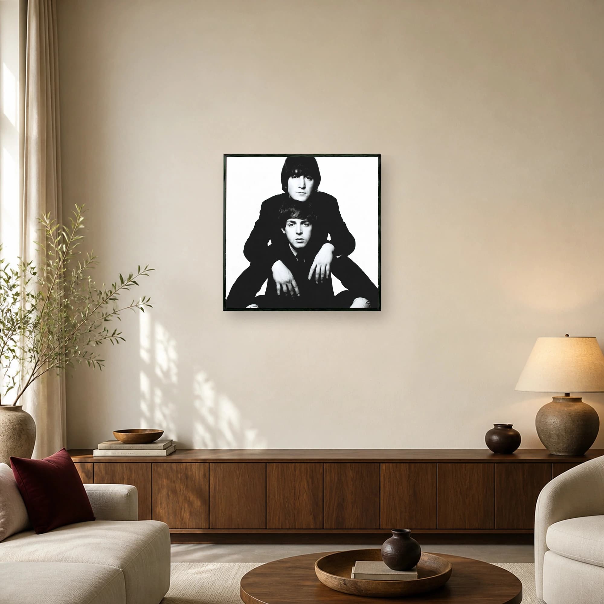 Black and white portrait of John Lennon positioned behind Paul McCartney against a solid white background.