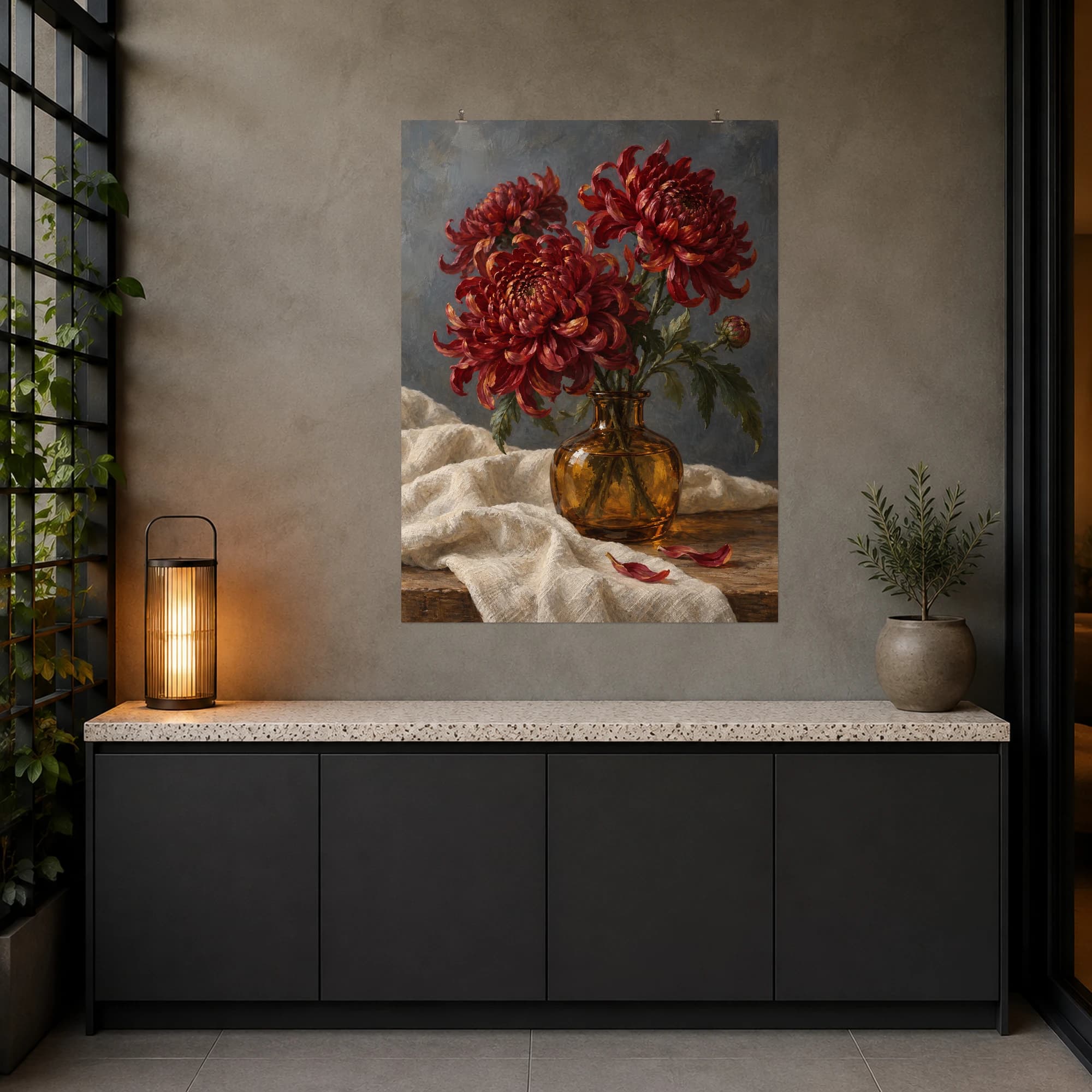 Red chrysanthemums rise from an amber vase against a slate-toned setting. Warm glass and layered petals create a rich floral still life.