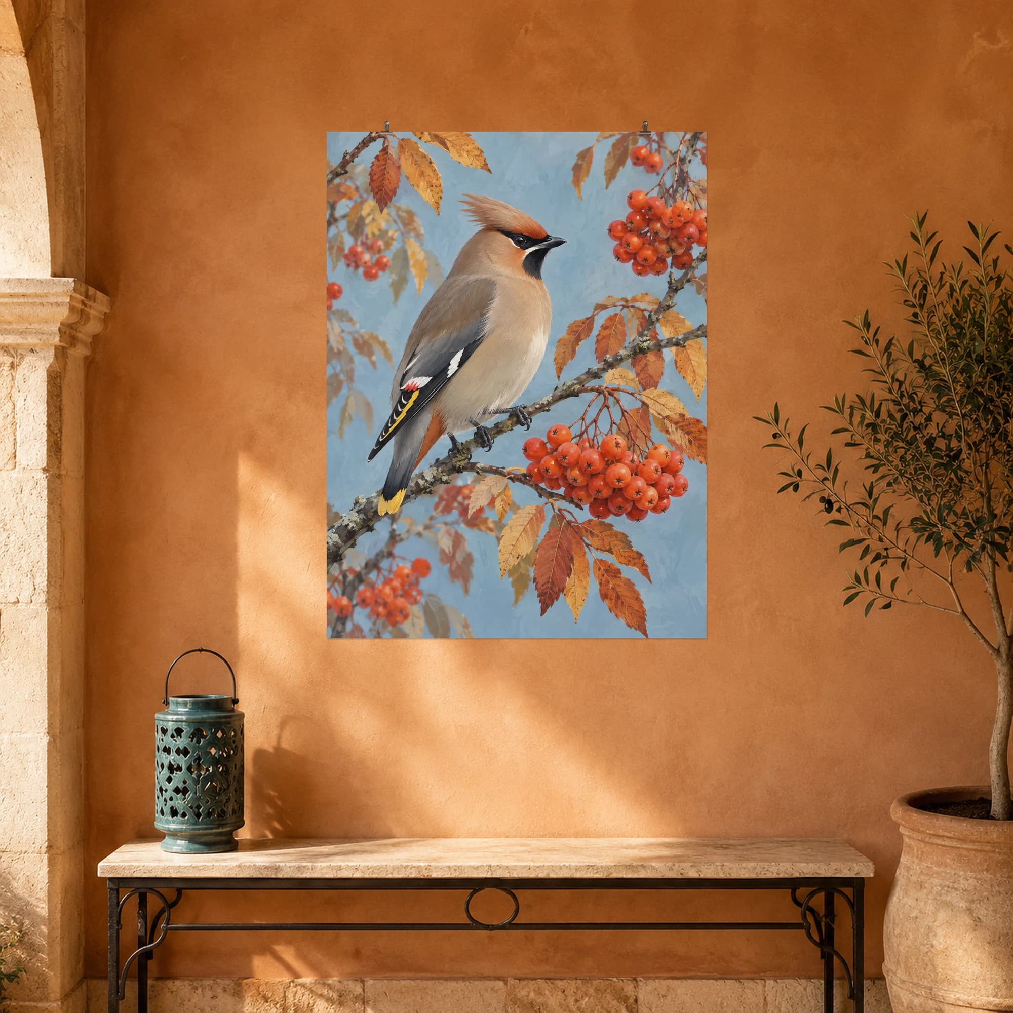 A waxwing perches among bright rowan berries against a soft blue autumn sky.