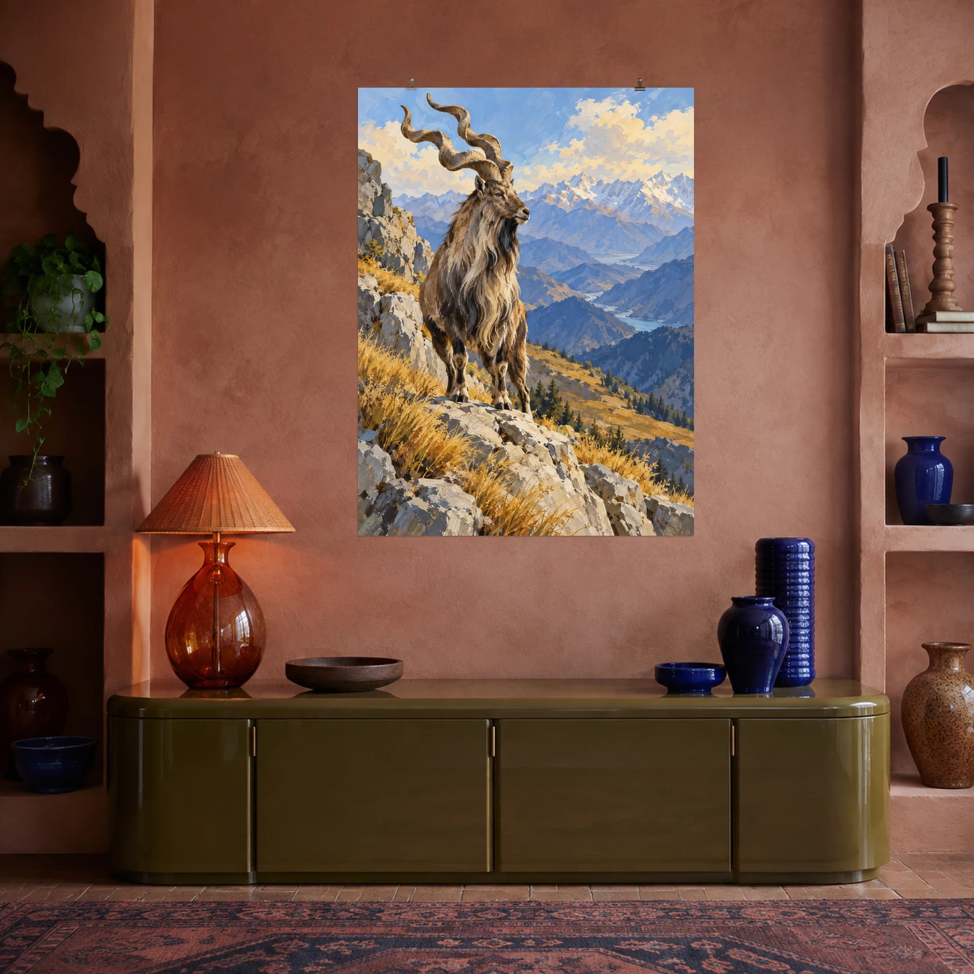 This gouache-style composition features a majestic markhor with spiraling horns standing on a pale rocky mountain ledge, distant blue ridges and golden alpine grasses. Expressive brushwork and a balanced palette bring warmth and character to your space.