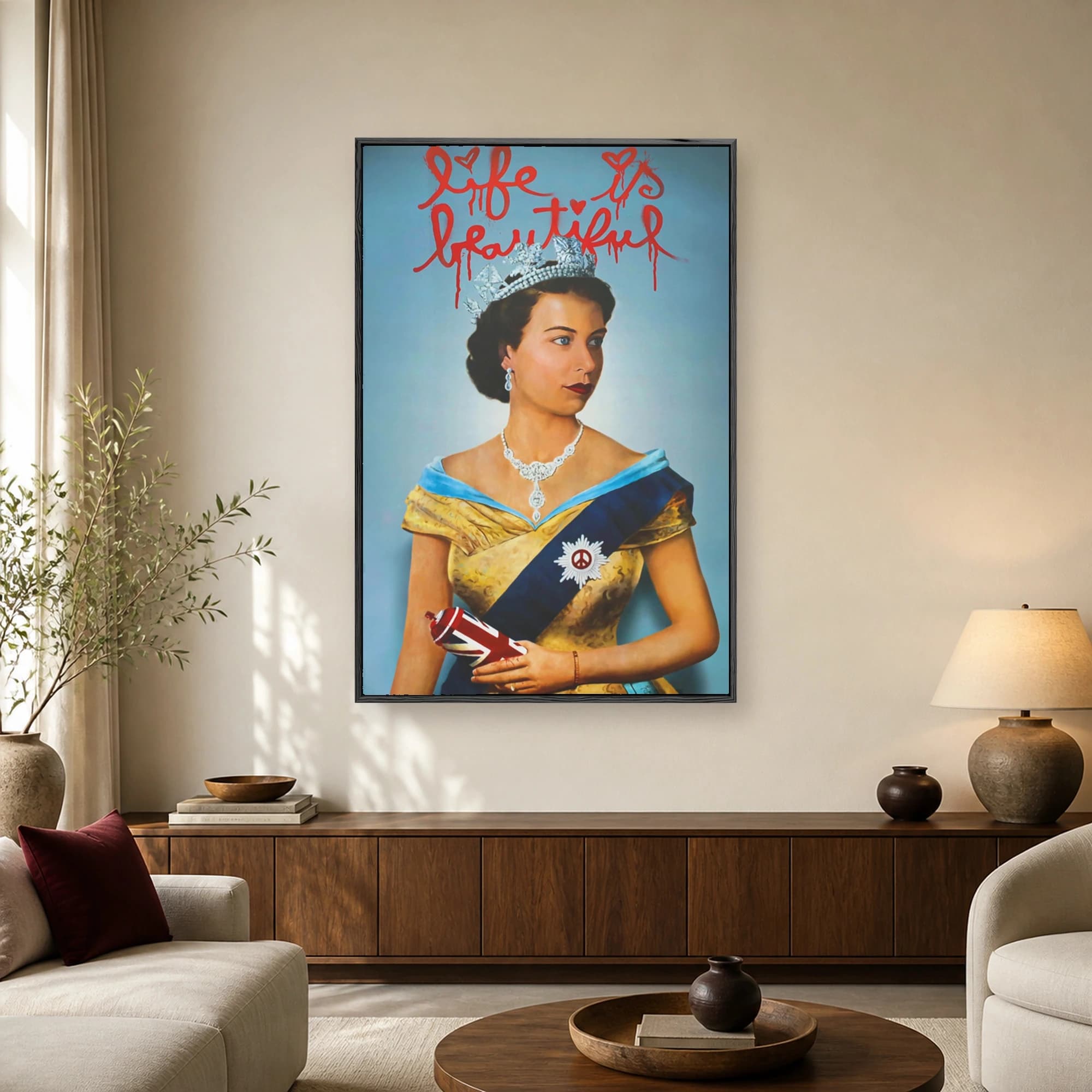 A portrait of Queen Elizabeth II wearing a crown and royal sash, overlaid with red dripping spray paint text reading Life is Beautiful and holding a Union Jack spray can.