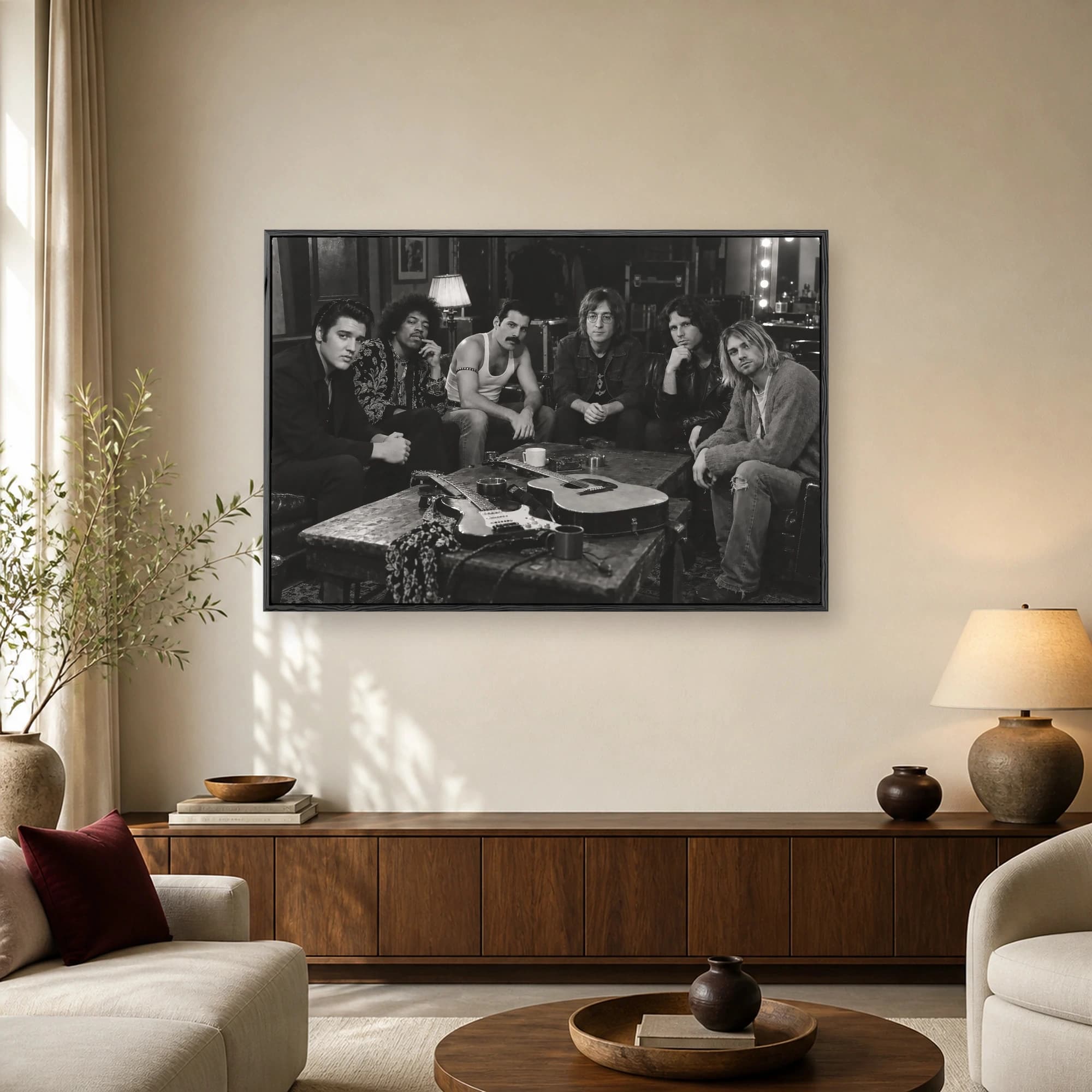 Black and white photo of rock legends Elvis, Hendrix, Mercury, Lennon, Morrison, and Cobain sitting together around a table with guitars.