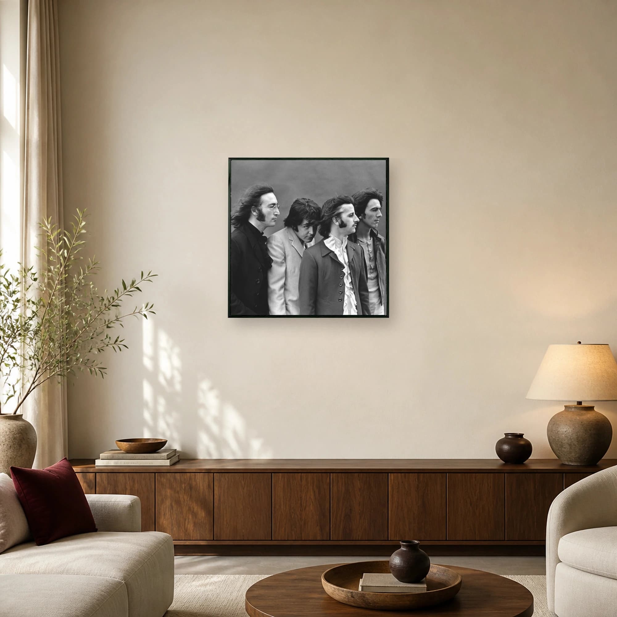 Black and white portrait of The Beatles band members in tailored vintage clothing against a neutral backdrop