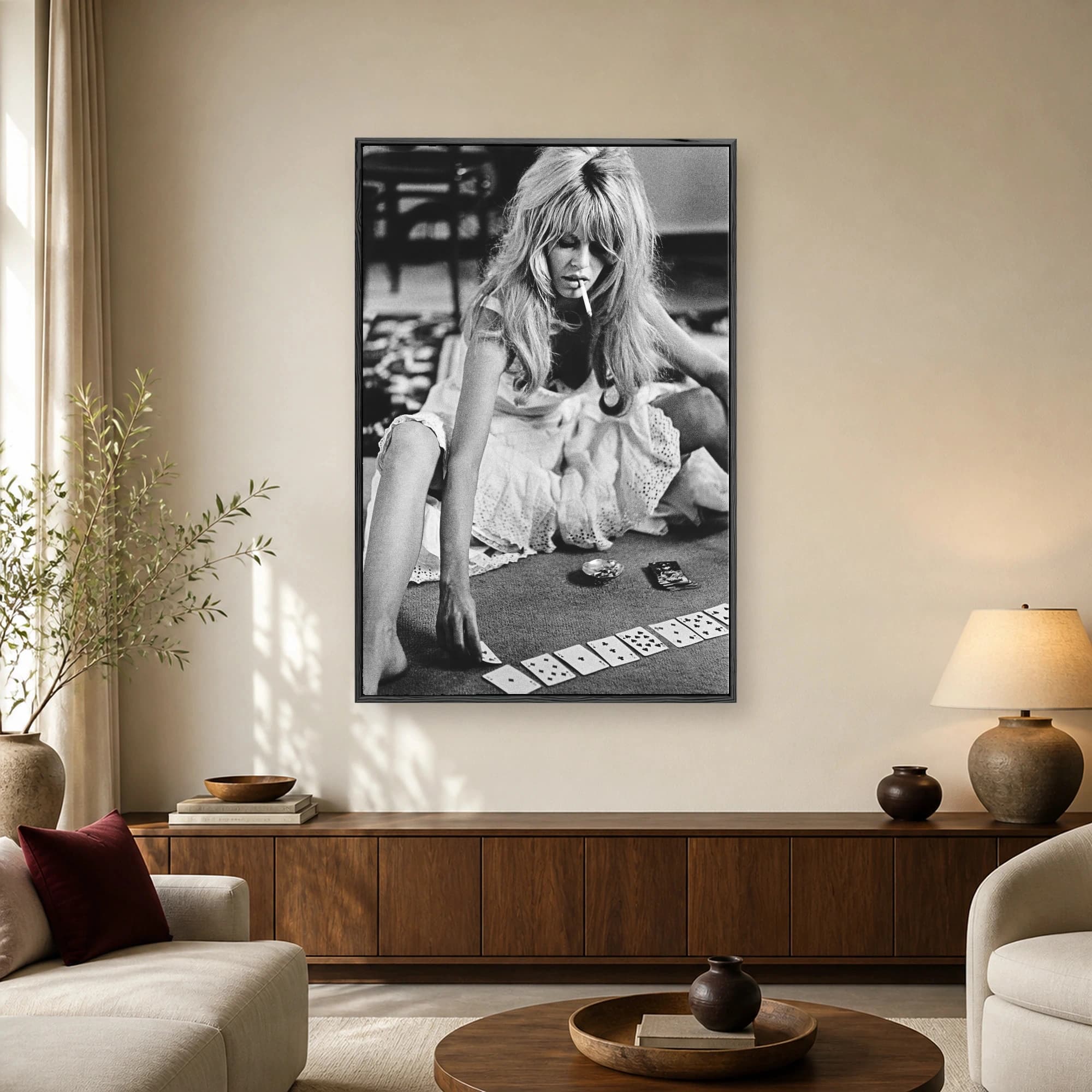 Vintage black and white photograph of Brigitte Bardot seated on a carpet with a cigarette and playing cards.