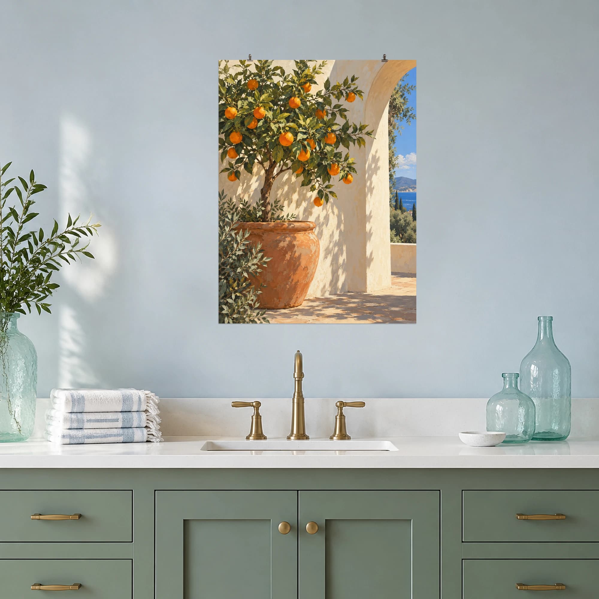 A fruit-laden orange tree catches the sunlight beside an ivory archway. Terracotta, leafy greens and a glimpse of blue sea give this courtyard scene an inviting Mediterranean mood.