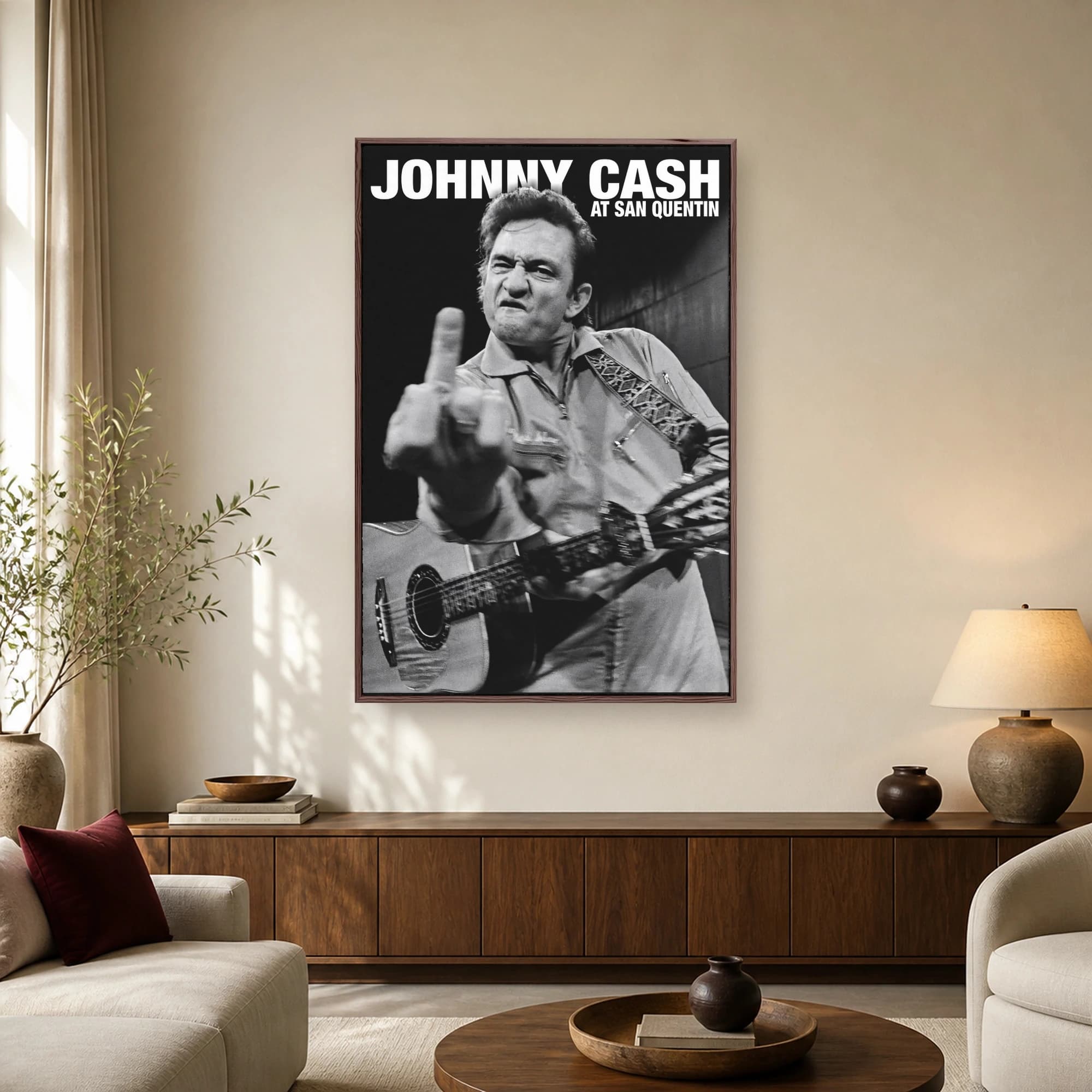 Black and white portrait of Johnny Cash holding an acoustic guitar and making a defiant gesture with bold text overhead.