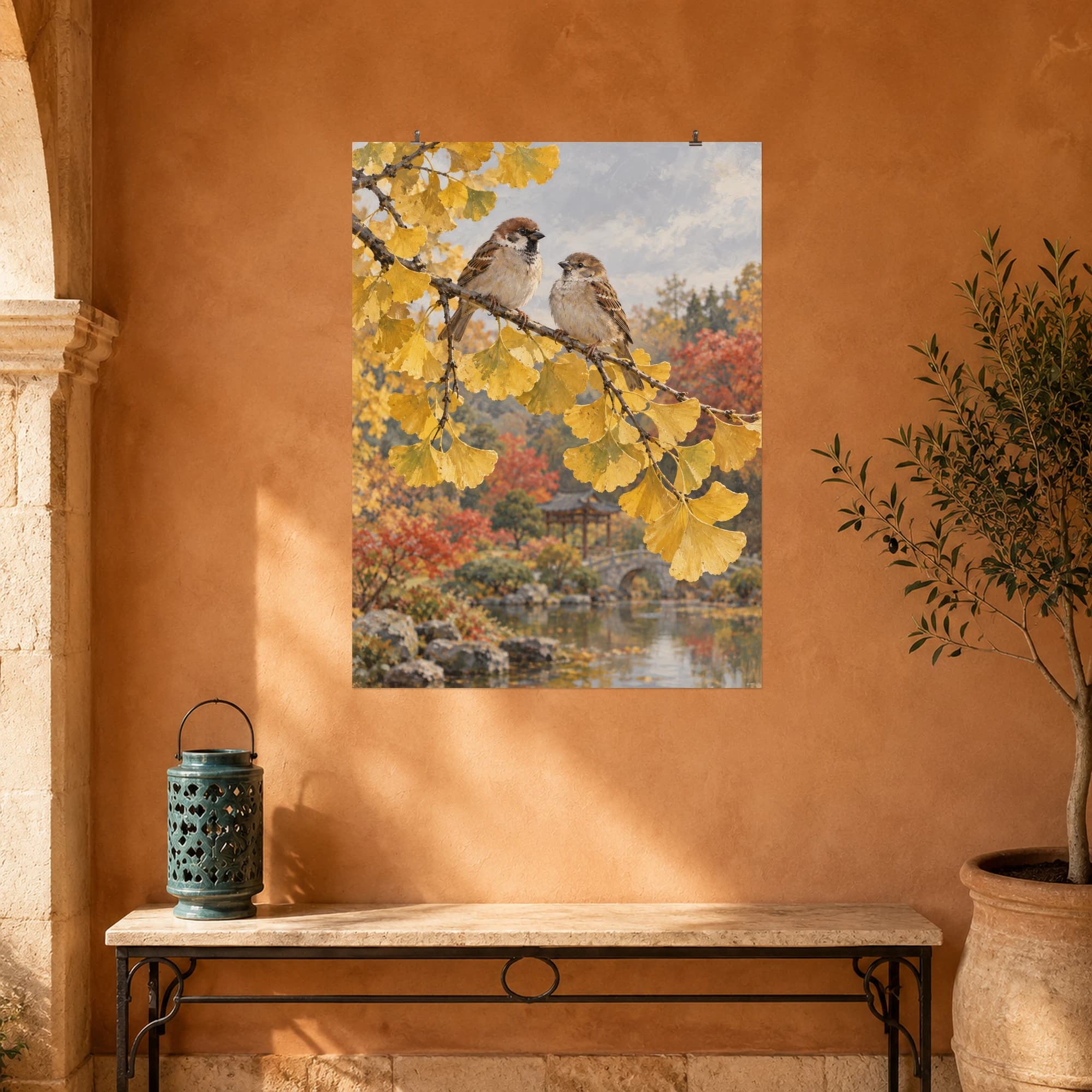 Two sparrows perch among golden ginkgo leaves beside an autumn pond. Muted reflections surround the bright foliage.