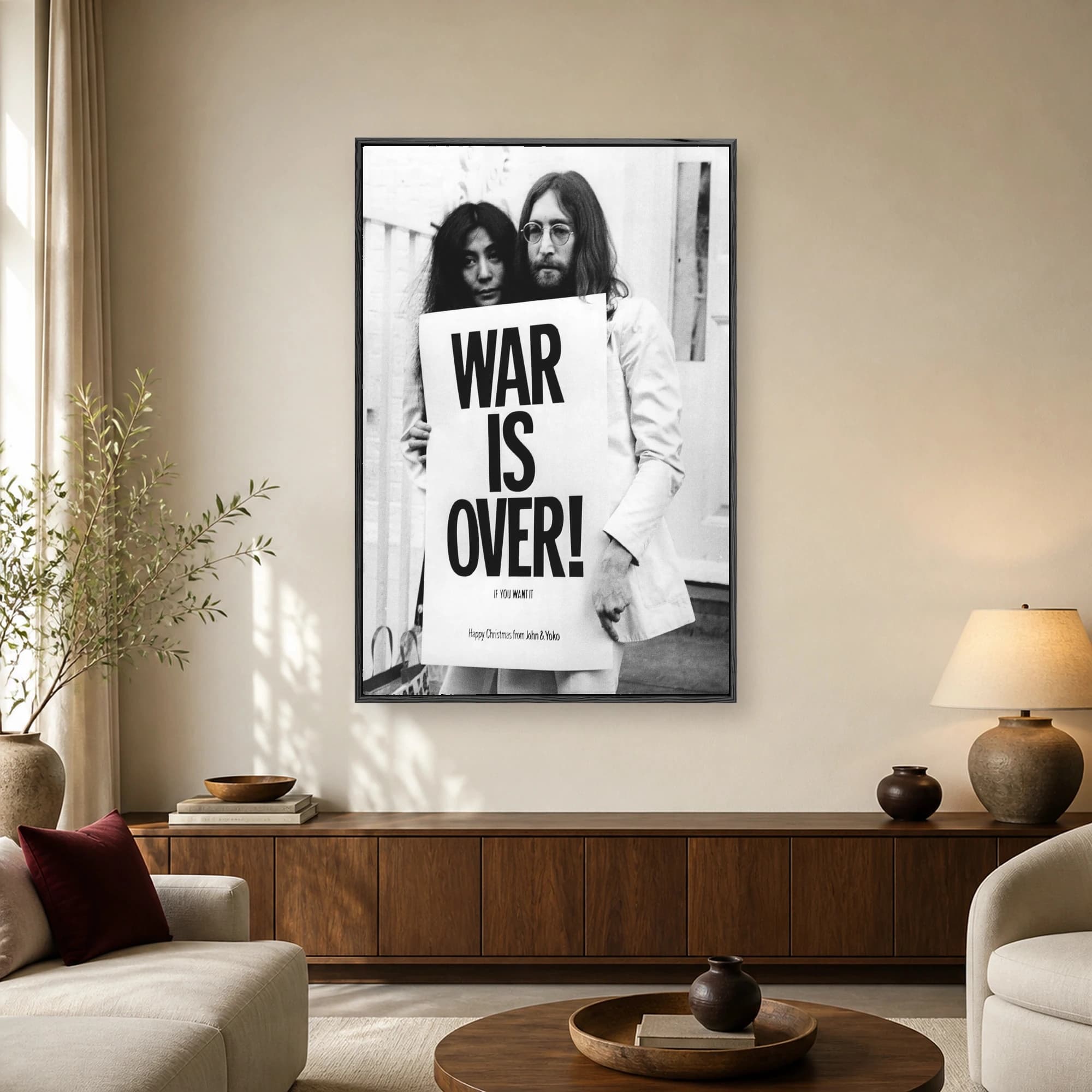 Black and white portrait of John Lennon and Yoko Ono holding a large sign that reads War Is Over if you want it.