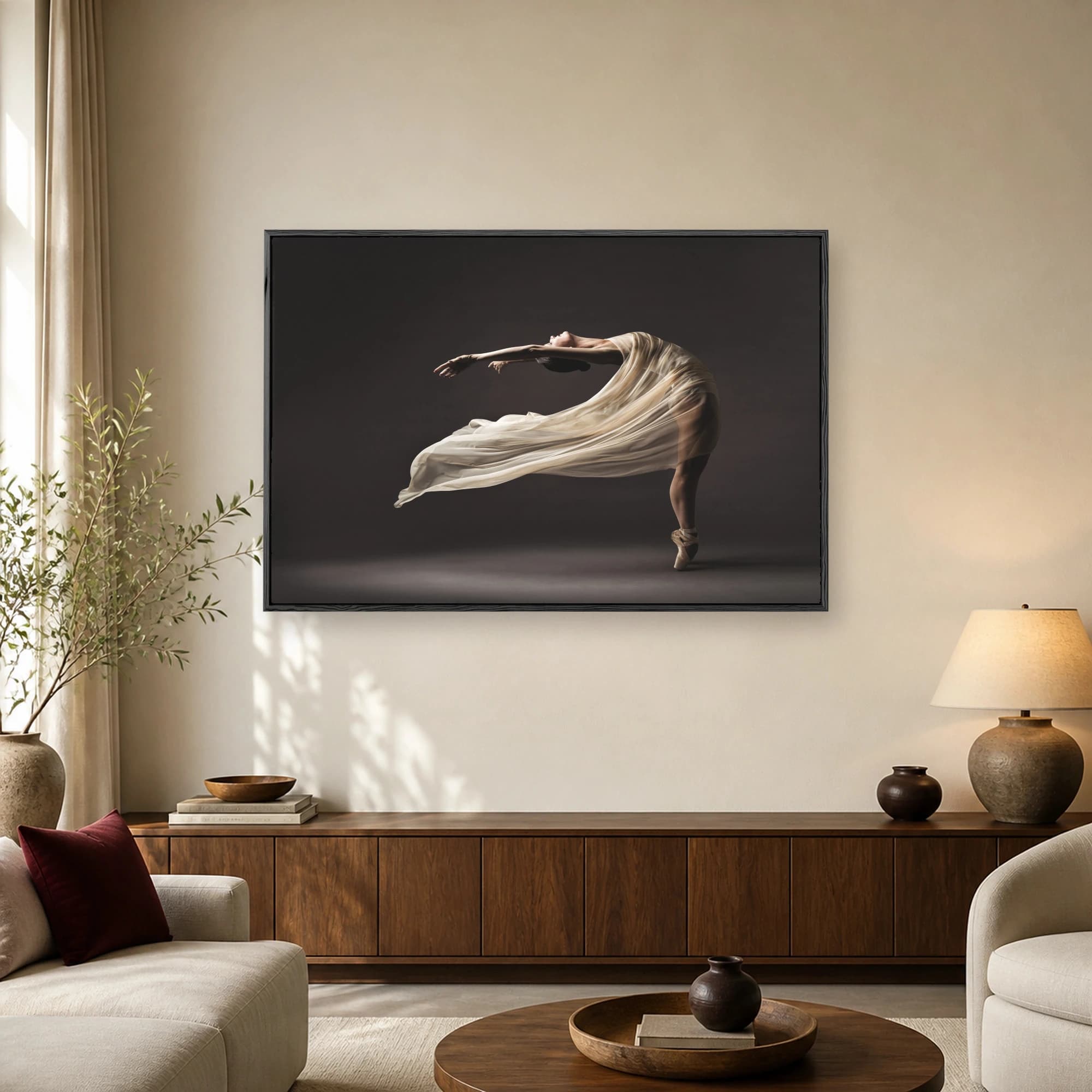 Fine art photography of a ballerina arching backward en pointe wearing a flowing cream dress against a dark background