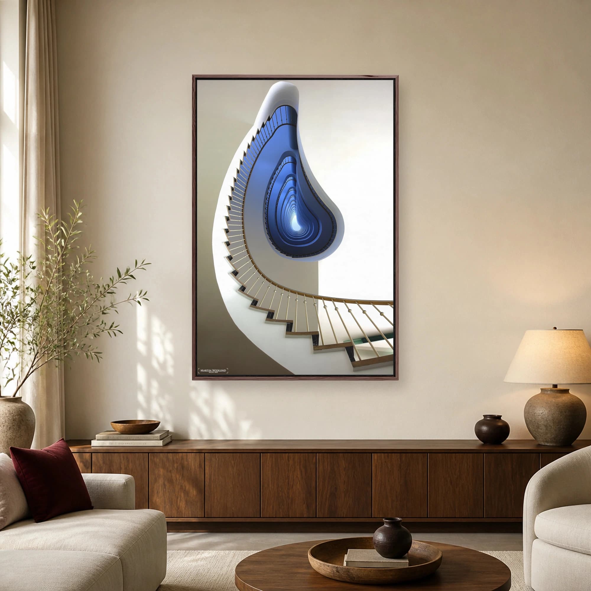A worm's-eye view looking up a curved modern staircase with white walls, a wooden handrail, and a striking deep blue gradient interior well.