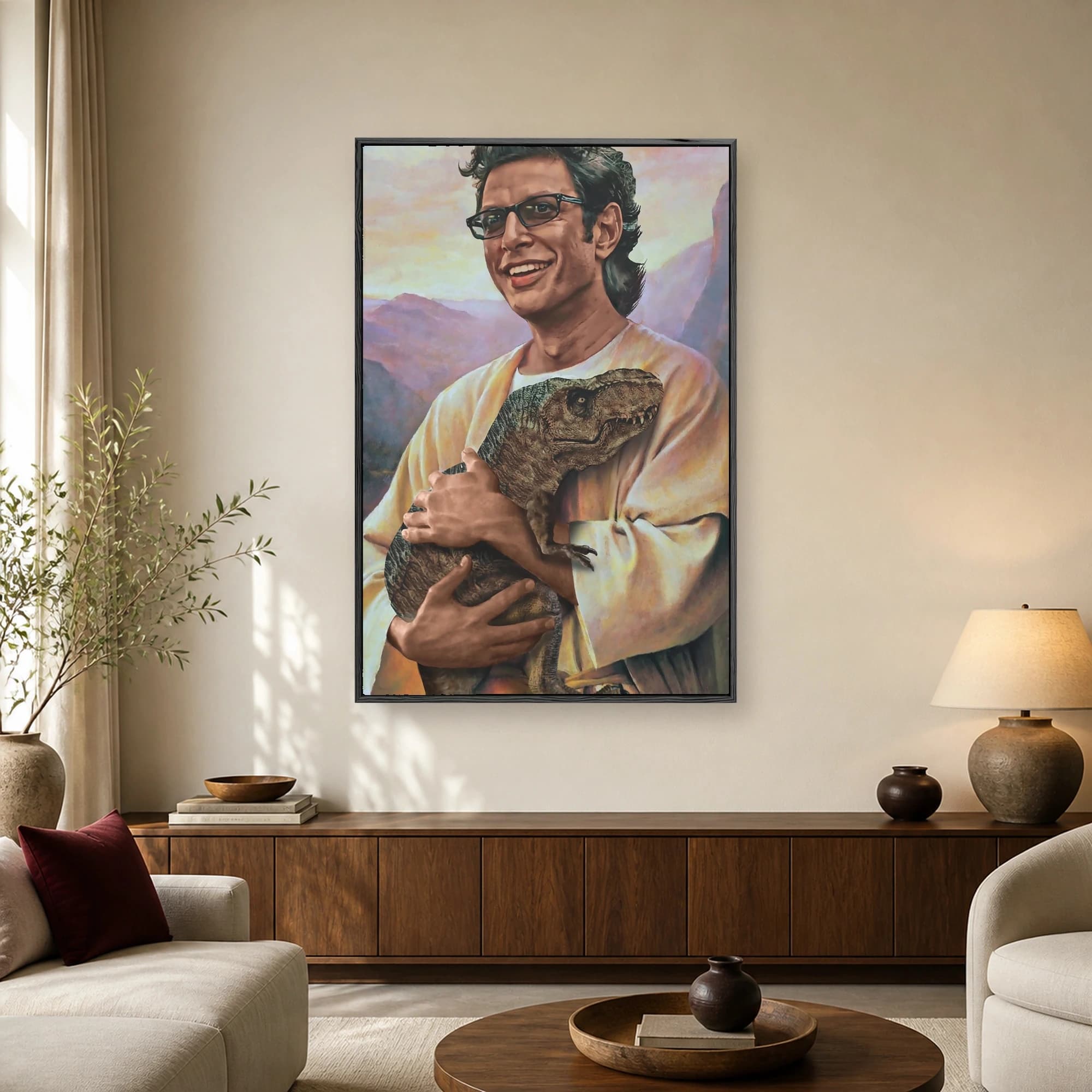 Parody painting of actor Jeff Goldblum wearing glasses and robes while tenderly holding a baby dinosaur against a soft mountain background.
