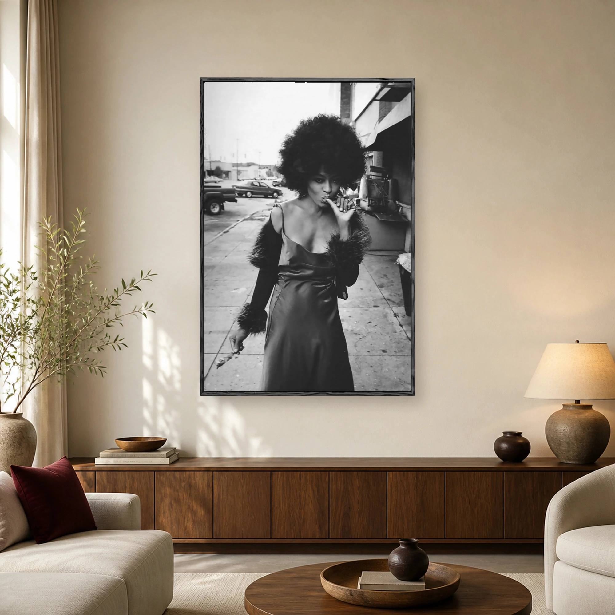 Black and white portrait photograph of a woman with a large afro hairstyle wearing a slip dress with fur accents on an urban street.