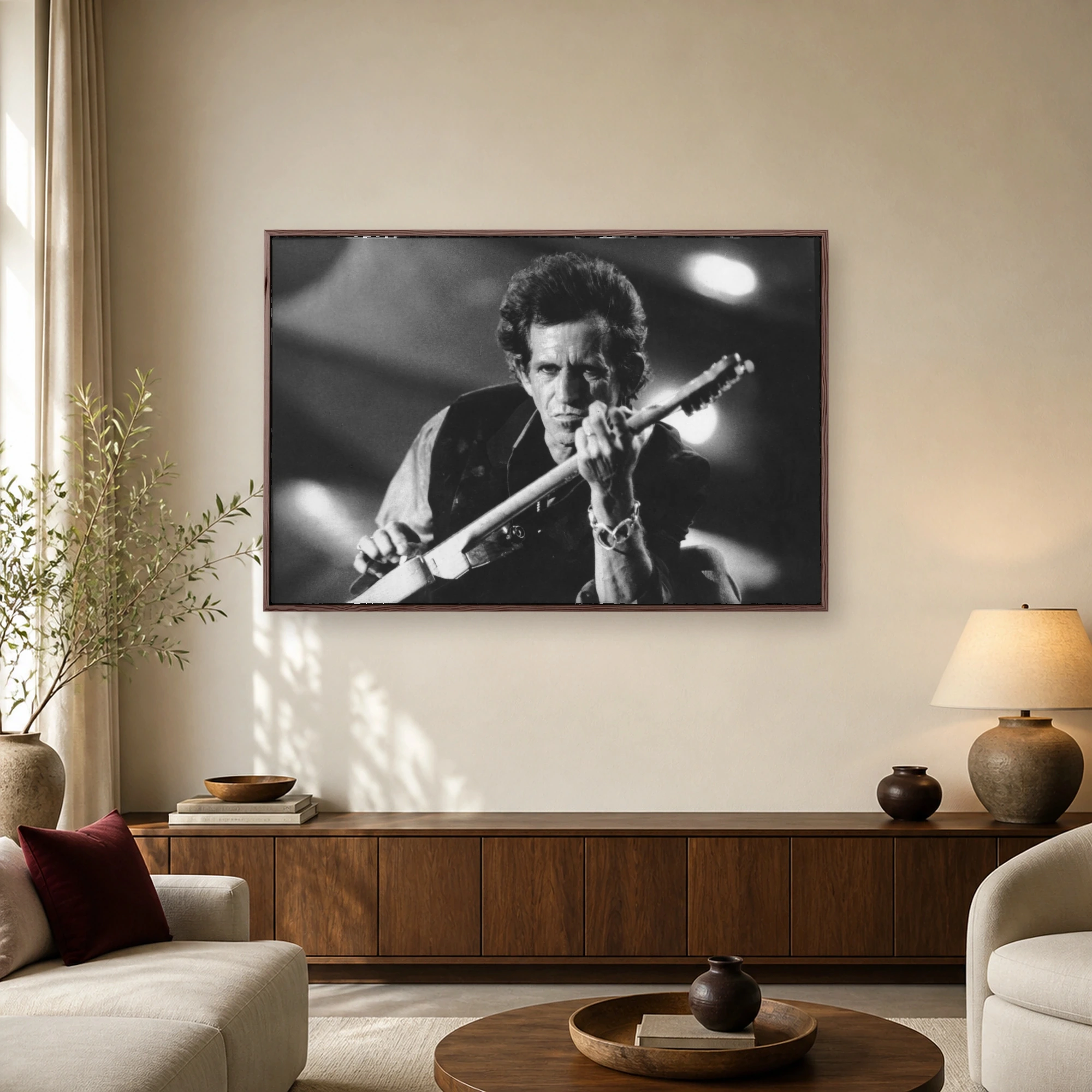 Black and white concert photograph of rock legend Keith Richards intensely playing an electric guitar under dramatic stage lights