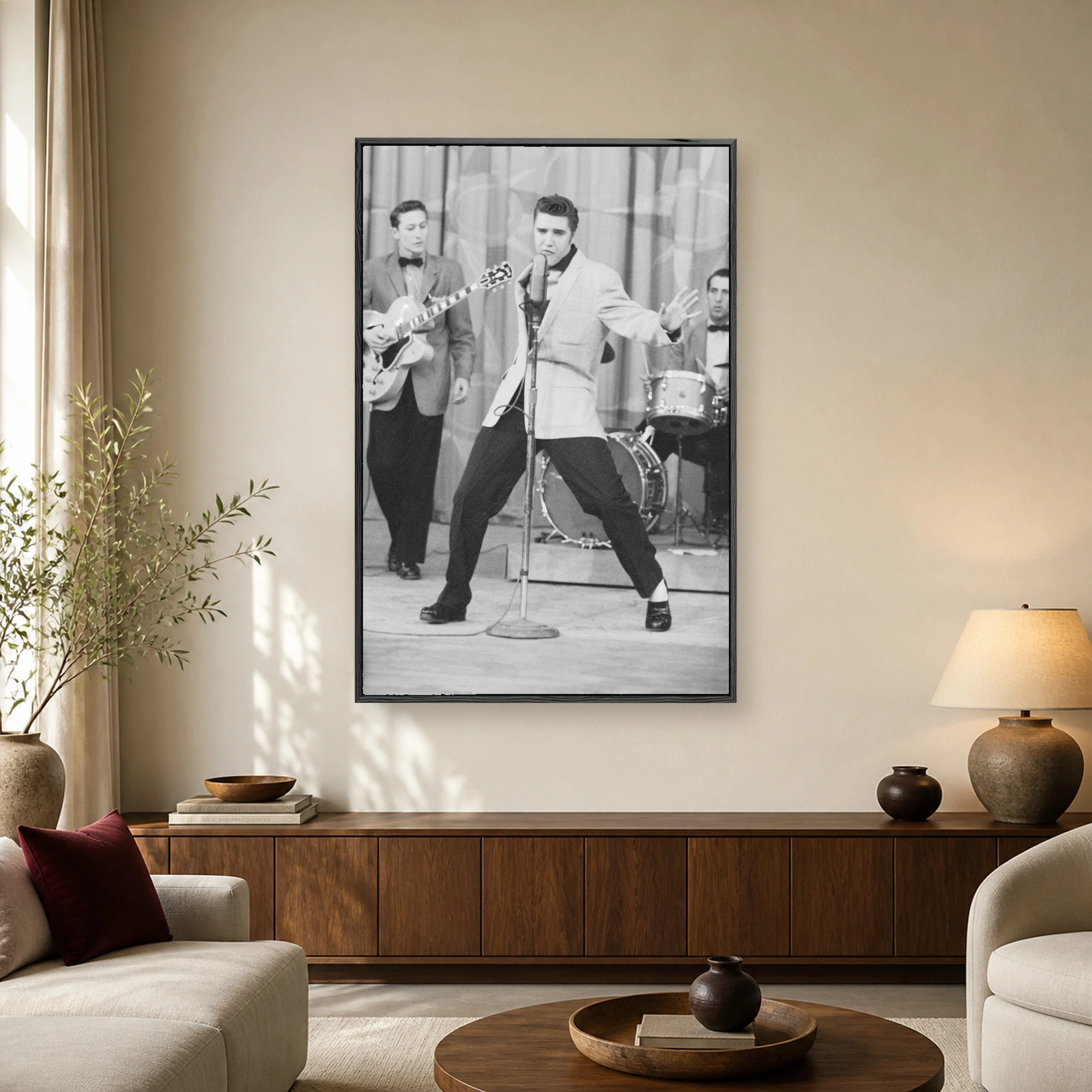 Black and white vintage photograph of Elvis Presley singing dynamically into a microphone on stage with his band