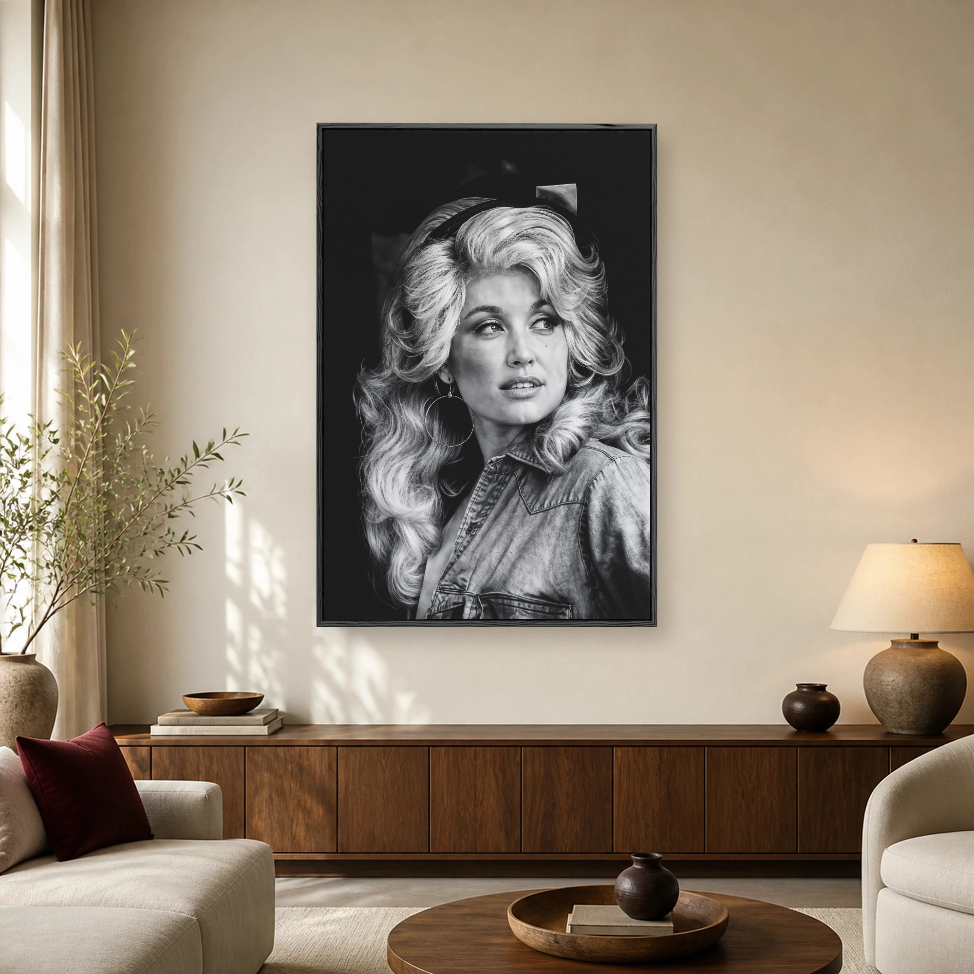 Black and white photographic portrait of a glamorous blonde woman with voluminous hair wearing a denim shirt and hoop earrings.