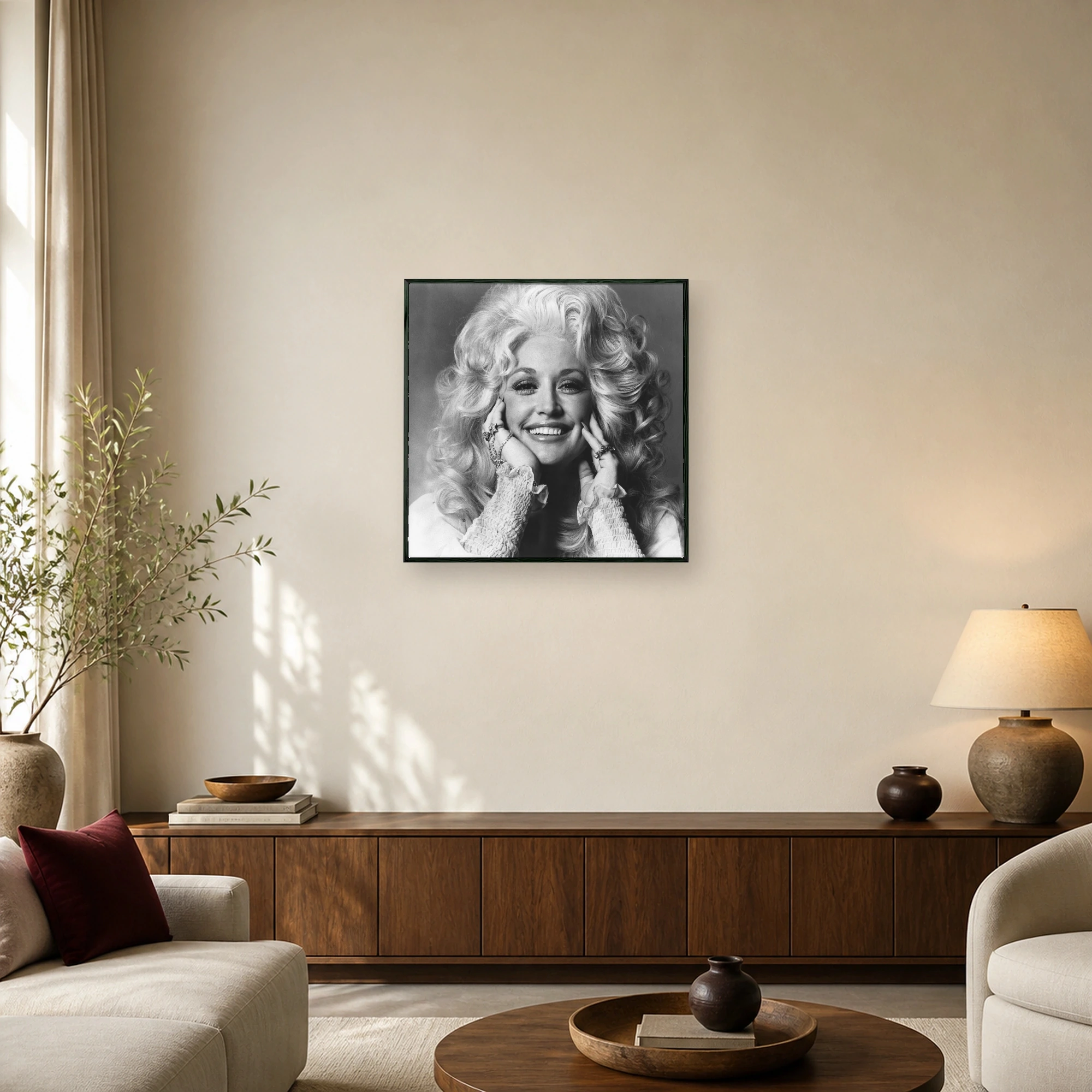 Black and white portrait of Dolly Parton with voluminous blonde hair framing her smiling face, wearing ruffled sleeves and statement rings.