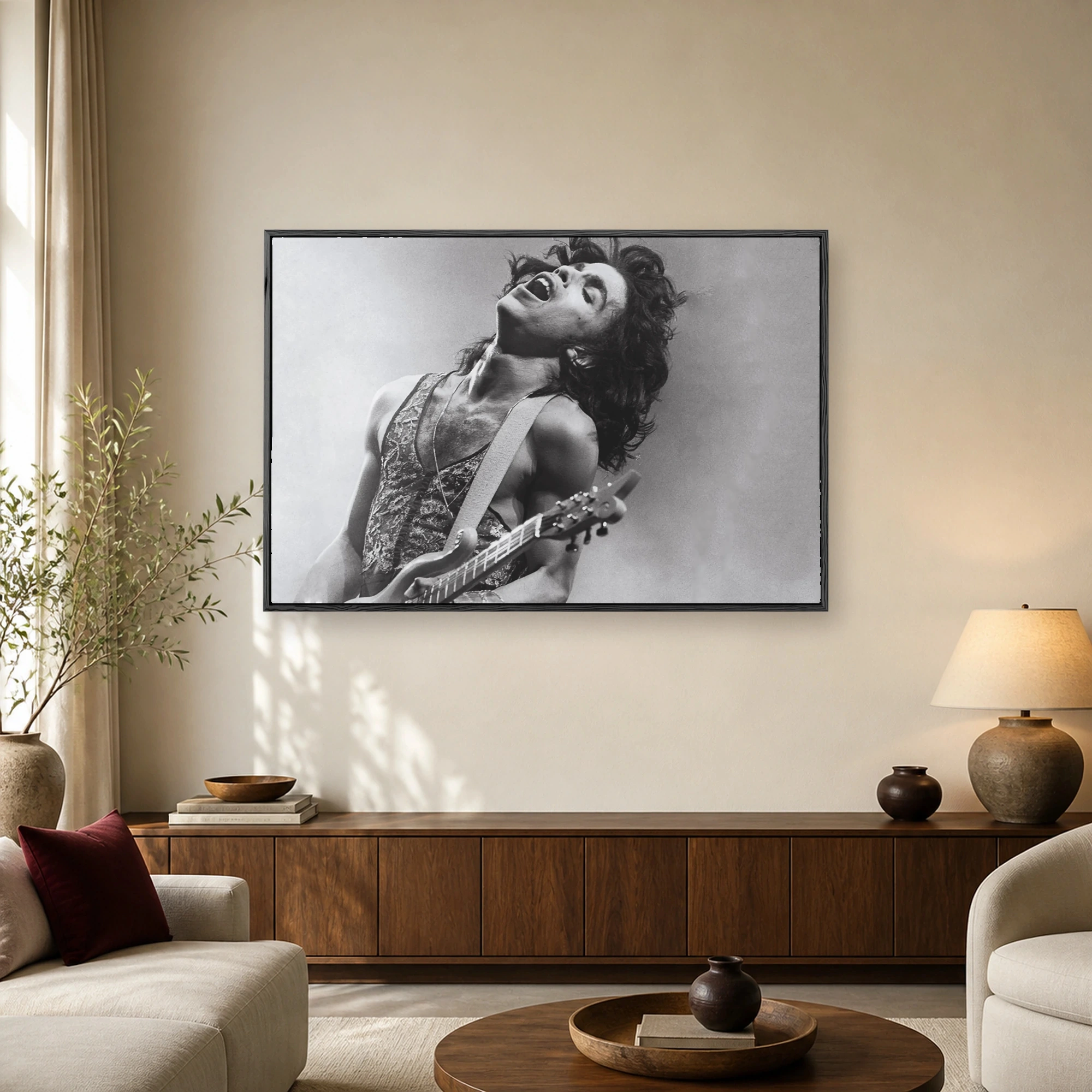 Black and white portrait of Prince singing passionately while playing guitar on stage.