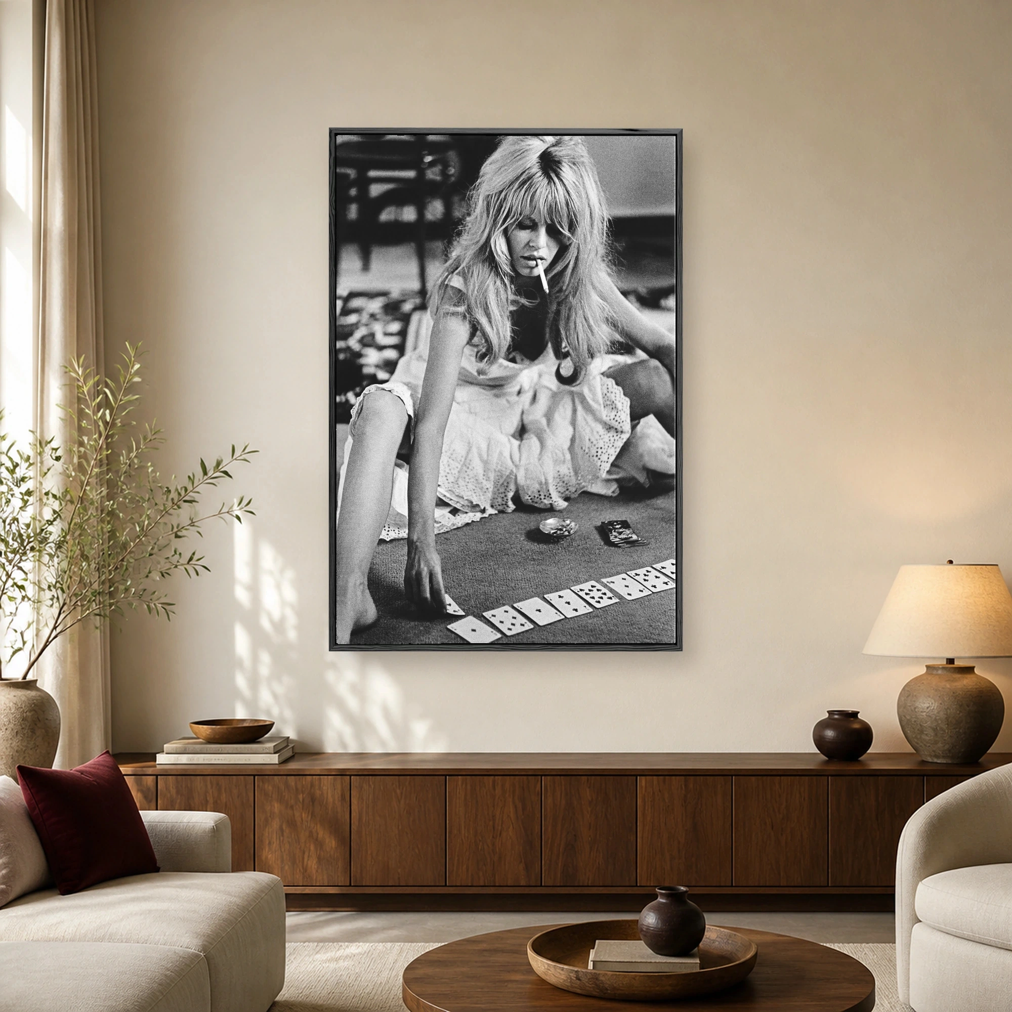 Vintage black and white photograph of Brigitte Bardot seated on a carpet with a cigarette and playing cards.